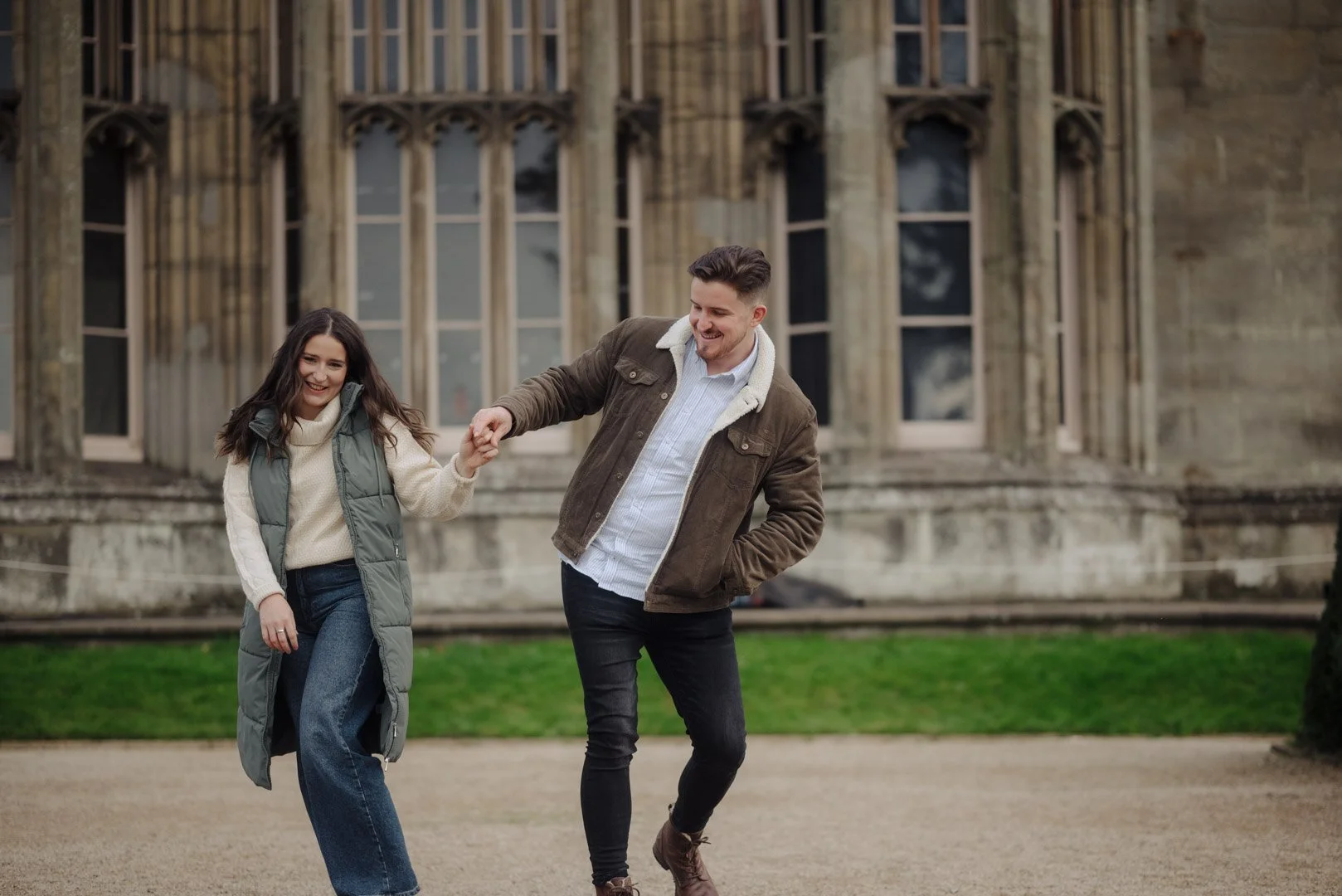 Man and woman holding hands walk in a funny manner and are laughing