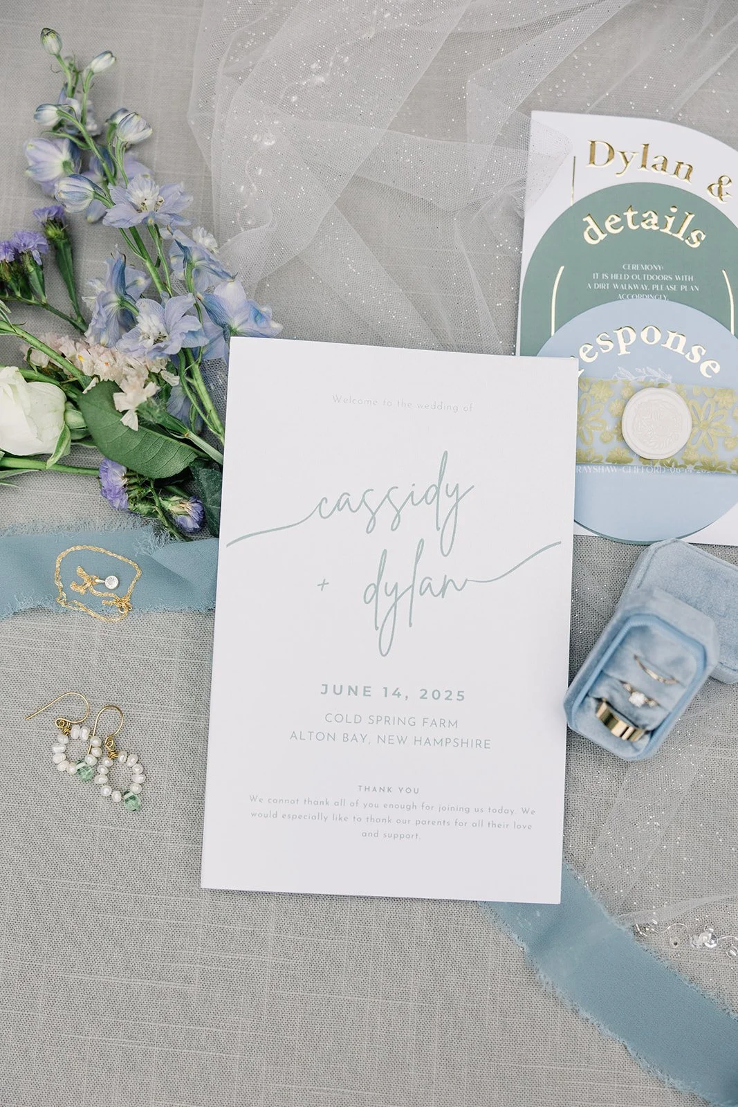 Wedding detail shot including wedding invitation, jewelry, and garden wedding flowers.