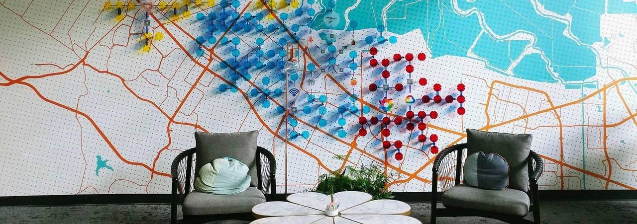 Colorful map-like wall artwork above seating in a contemporary interior.