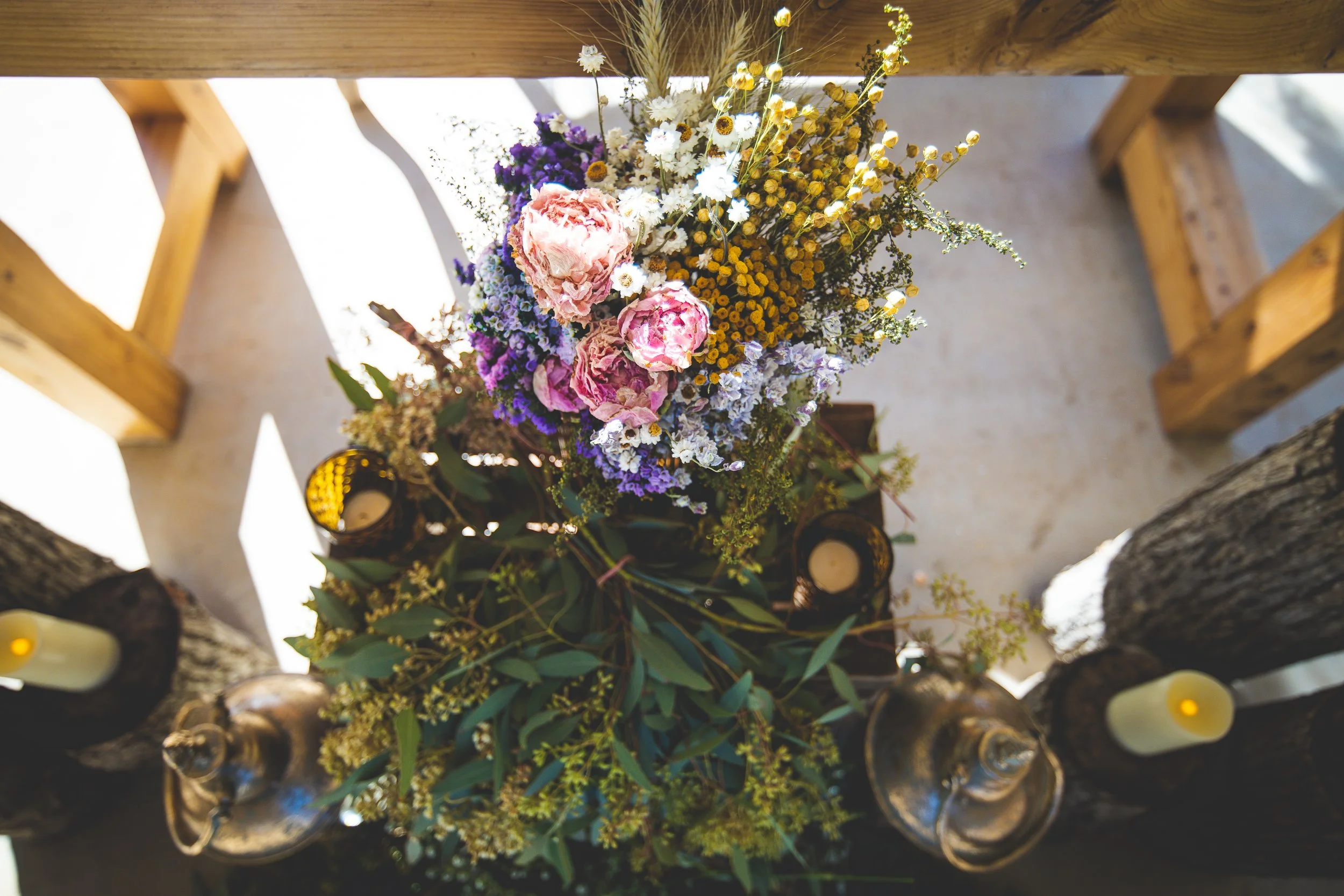A woodland bohemian bridal bouquet shot from above with dramatic shadows in Saint Louis.