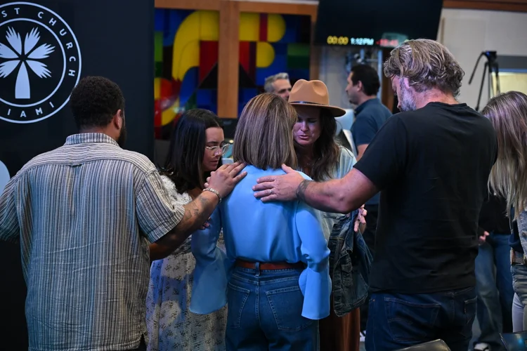 Harvest church members gathered closely in prayer