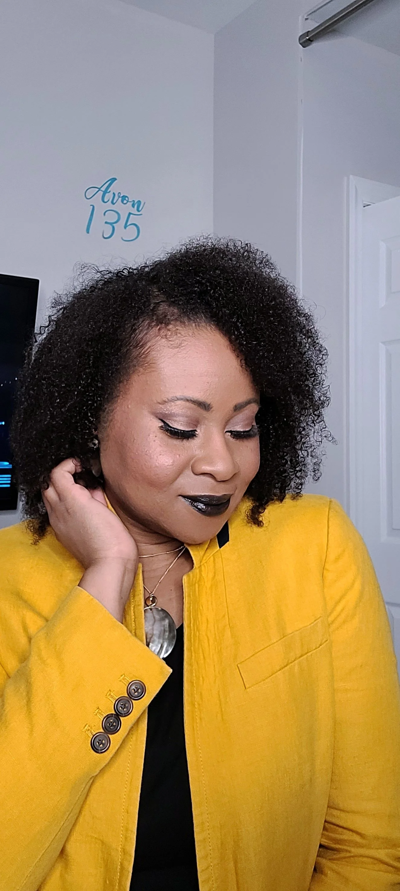 black woman with natural hair, black lipstick, and yellow j. crew blazer