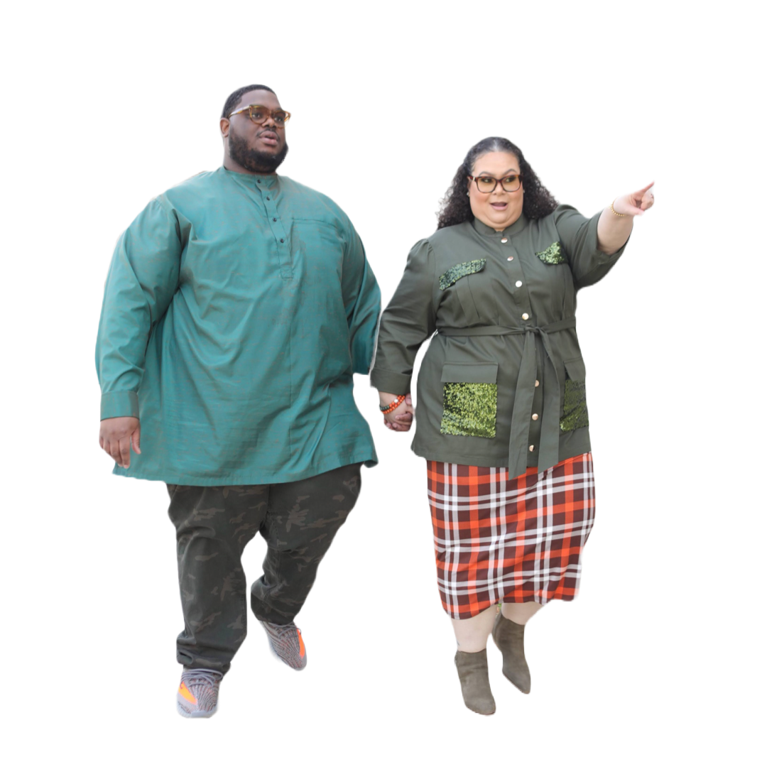 A man and woman holding hands, walking together, with the woman pointing forward. The man wears a teal traditional outfit with camouflage pants and sneakers, and the woman wears an olive green jacket with green patches, a plaid skirt, and gray boots.