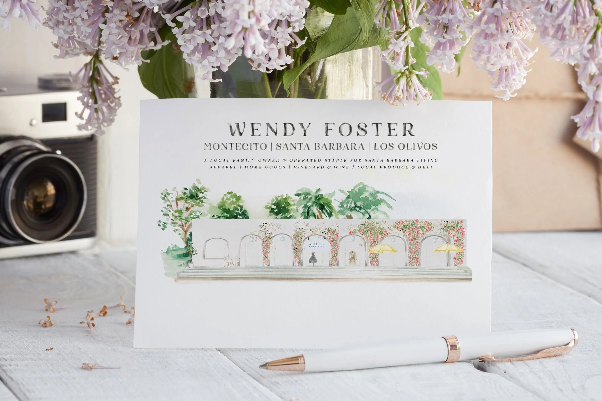 Styled mockup featuring the custom Angel Montecito architectural illustration created for the Wendy Foster destination map, showcasing the hand-illustrated storefront within the Santa Barbara, Montecito, and Los Olivos brand collection.