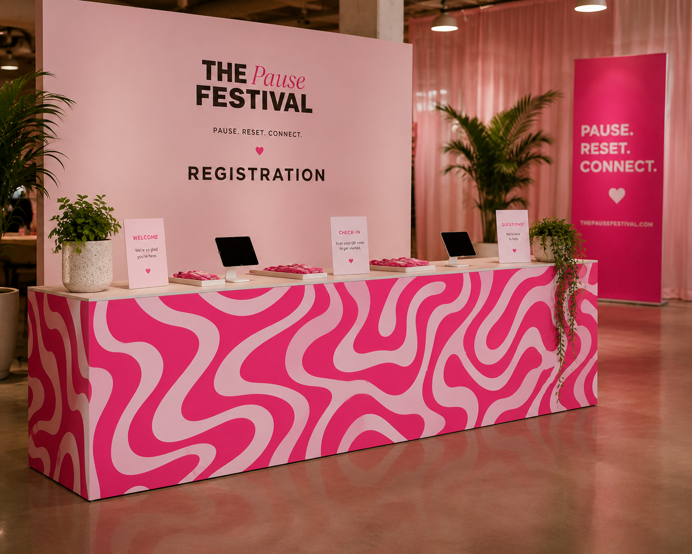 Pause Festival event branding mockup featuring a bold pink patterned registration desk, coordinated signage and environmental graphics.