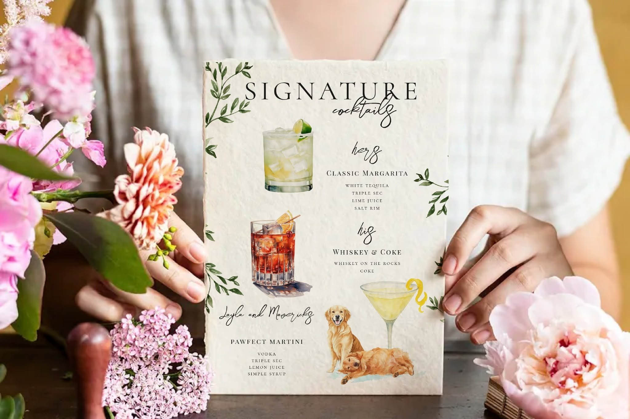 Wedding signature cocktail menu featuring hand-painted watercolor cocktails and custom illustrations of the couple's golden retrievers, displayed among fresh florals as personalized wedding bar signage.