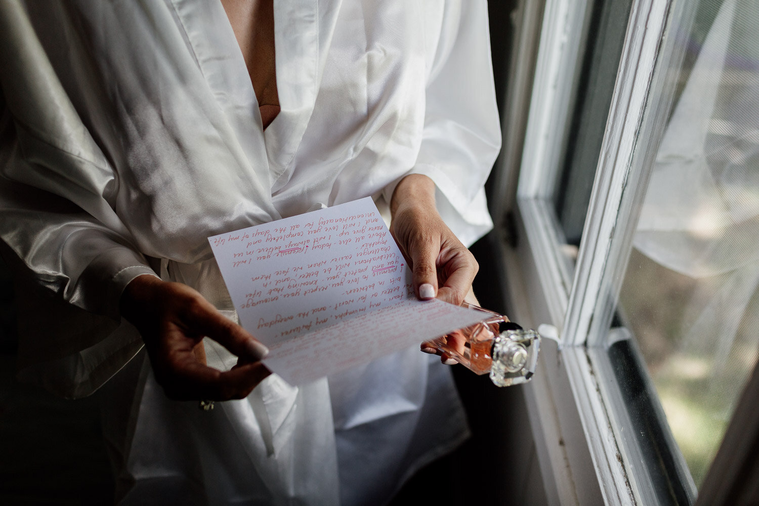 Bride reading vows at window