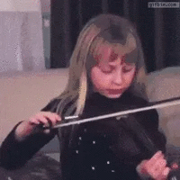 Une jeune fille joue du violon dans un salon