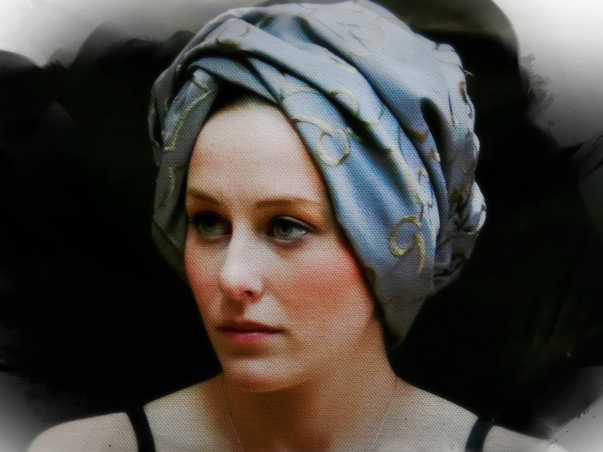 Close-up of a woman with a patterned headscarf, showing only the upper part of her face.