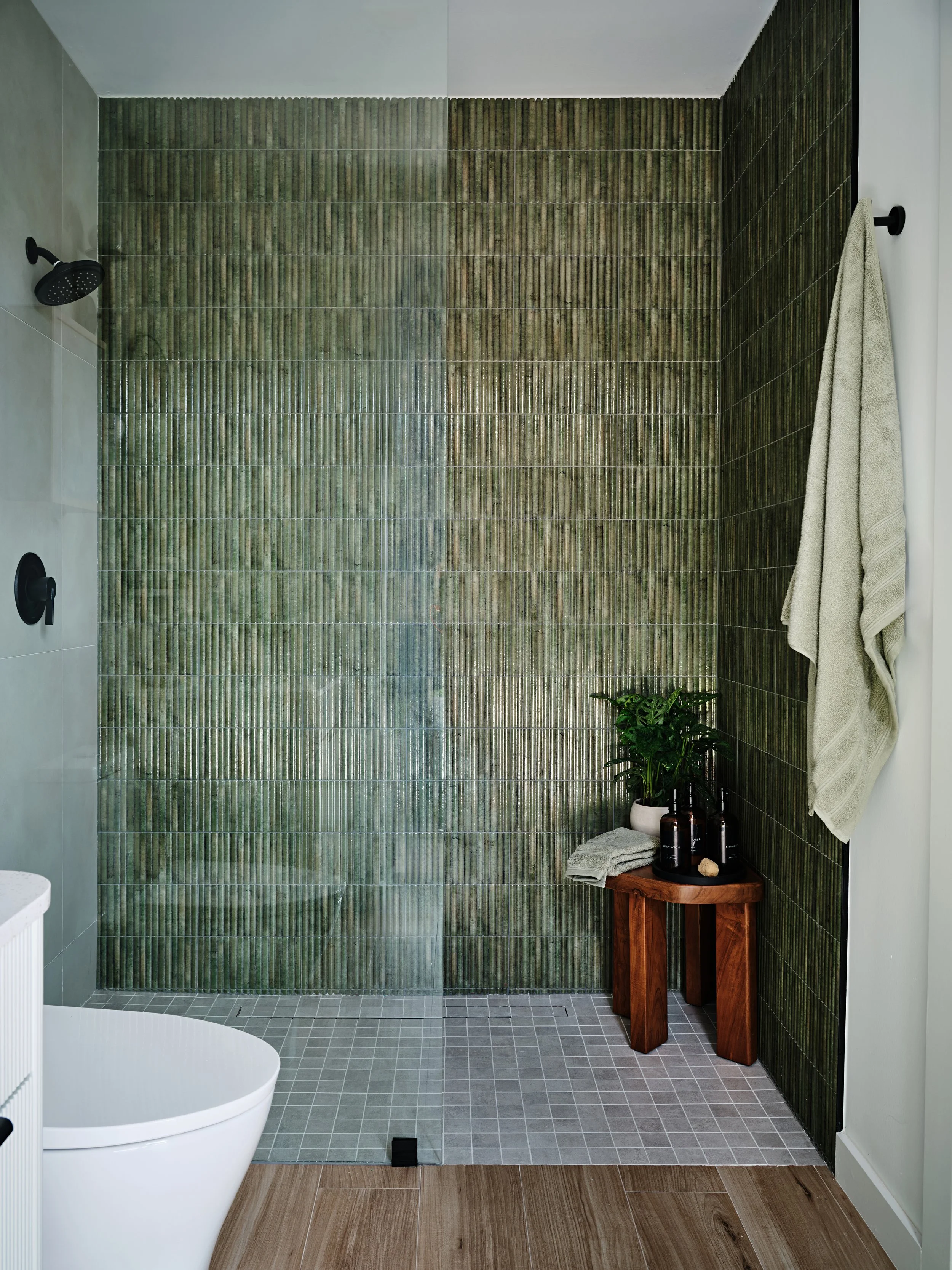 Green wall tile in Cabana bathroom. Shower with different tile combinations for a new construction residence in Miami, Fl. Interior design by Concept 2 Design.