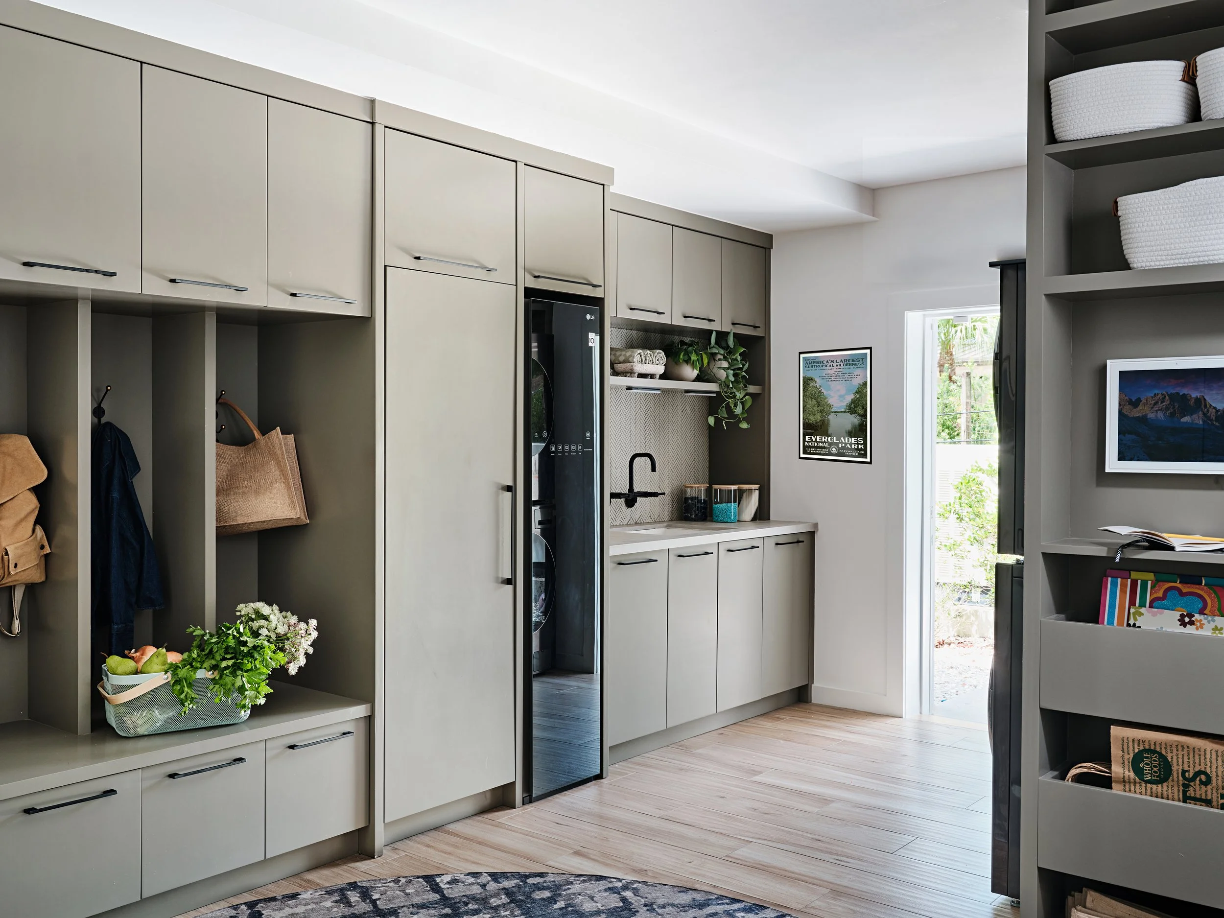 Khaki custom cabinetry in mudroom - laundry room. LG steamer in laundry room. New construction home in South Florida. Interior design by Concept 2 Design.