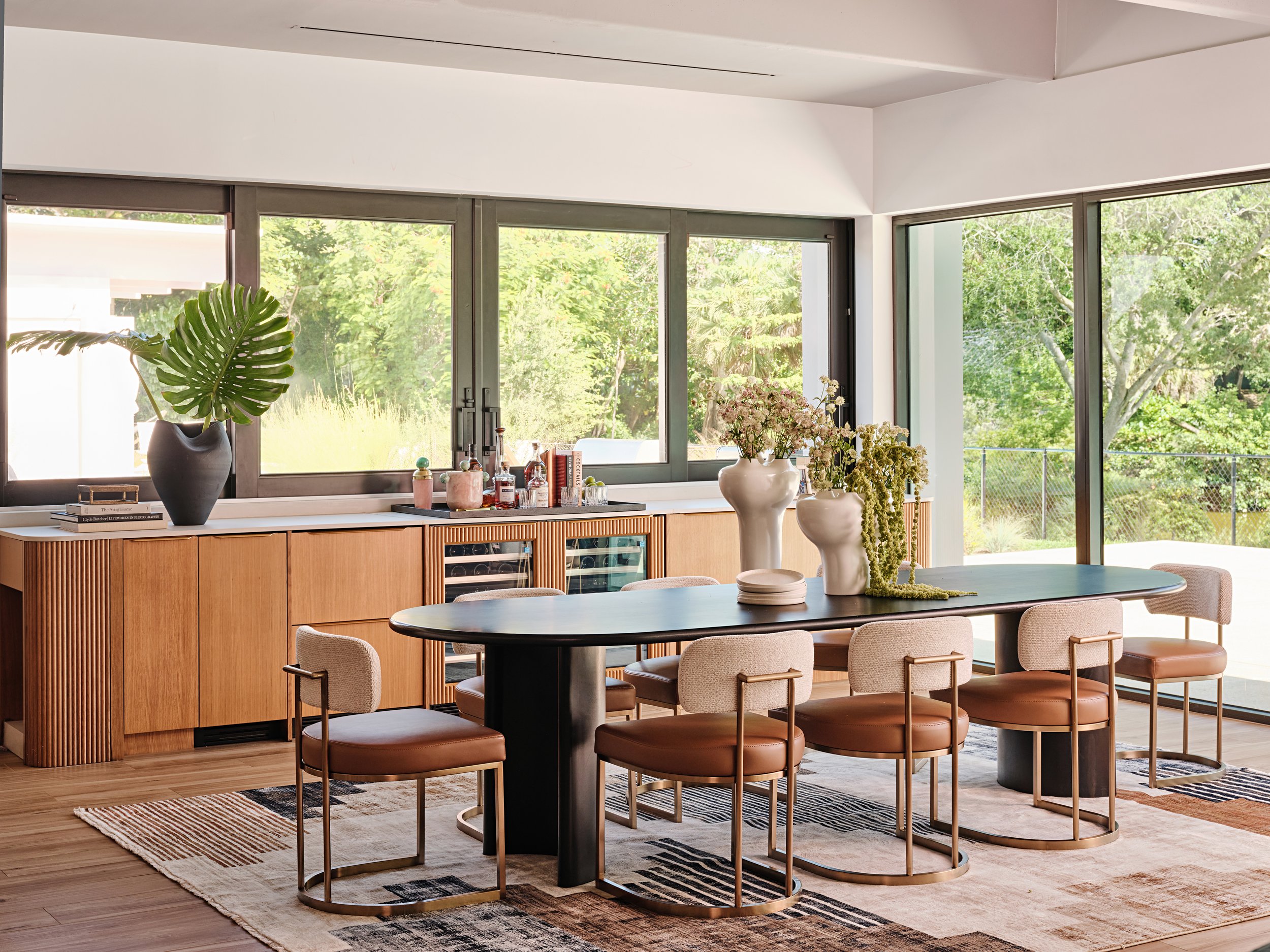 Black oval dining table with curved back dining chairs in a dining room in Kendall, Miami, Fl. Interior Design by Concept 2 Design