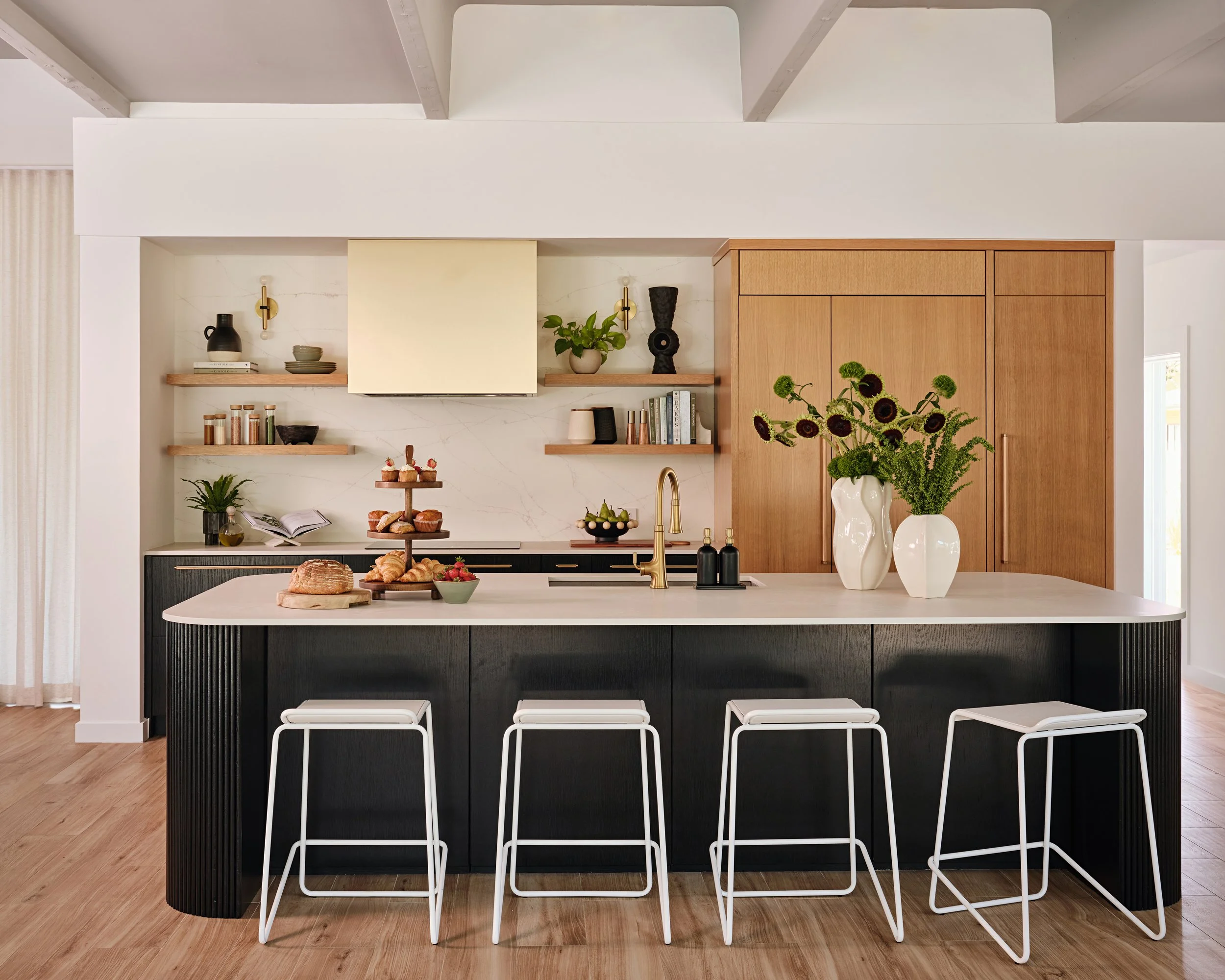 Custom built in cabinetry with black island cabinets and white oak wood cabinetry for a family home in Miami, Fl. Interior design by Concept 2 Design.