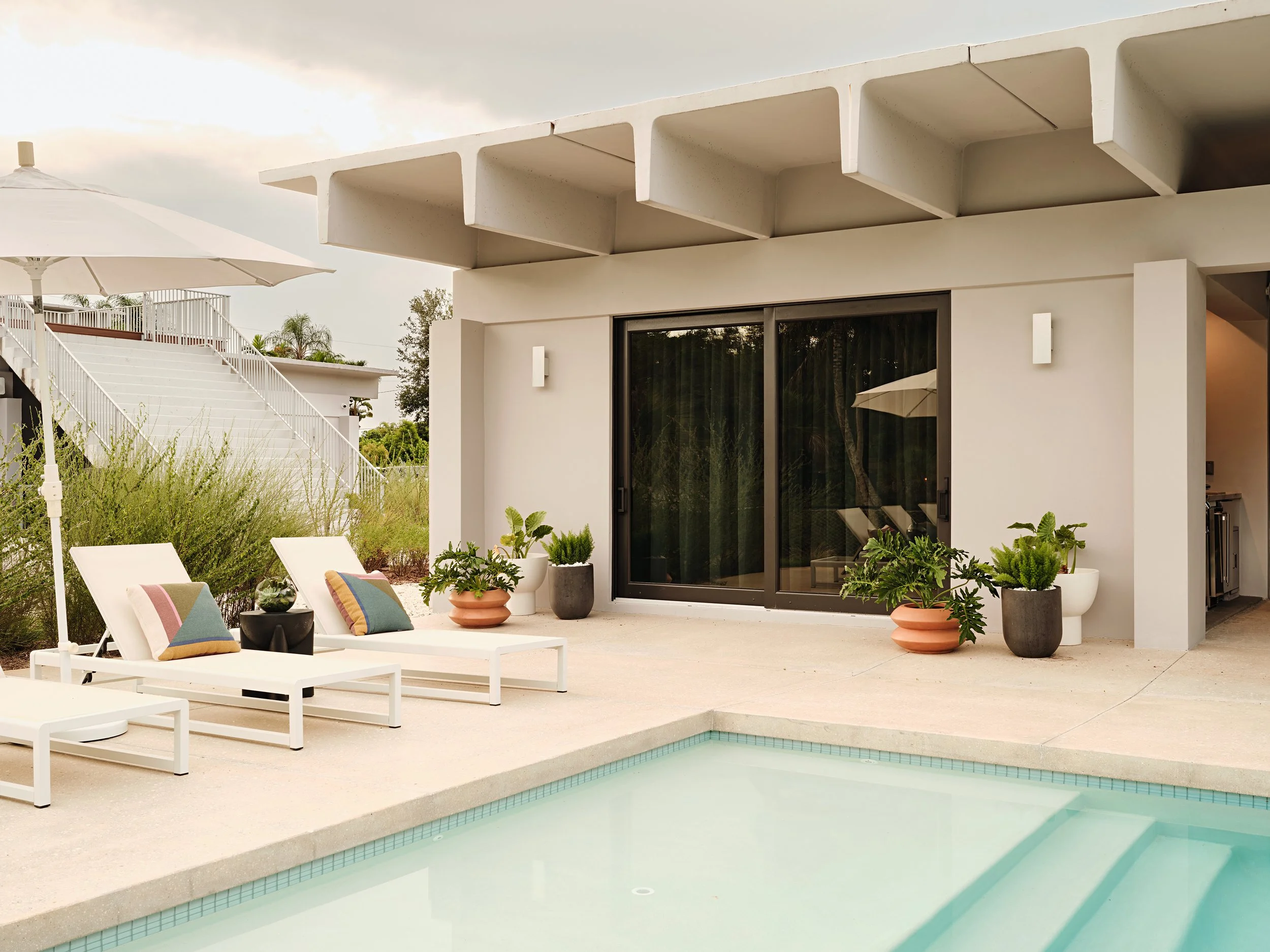 Pool deck with lounge chairs and covered terrace in South Florida.