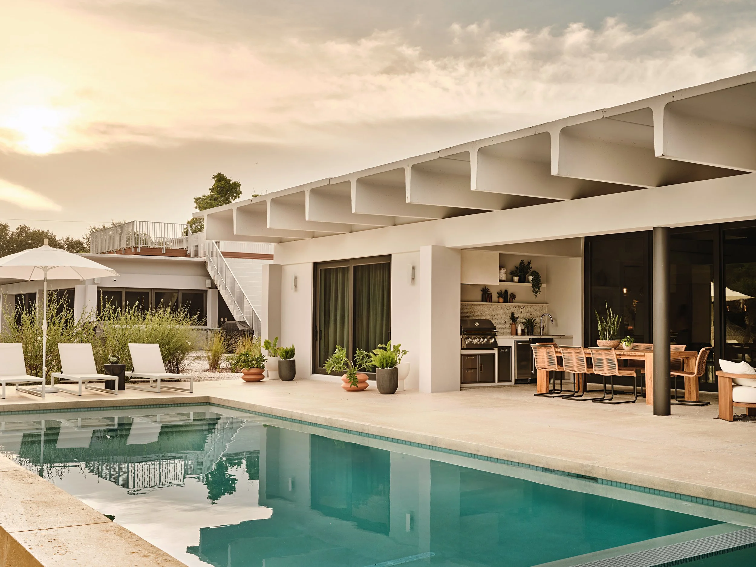 Modern home exterior with pool, covered patio and outdoor lounge in Kendall, FL