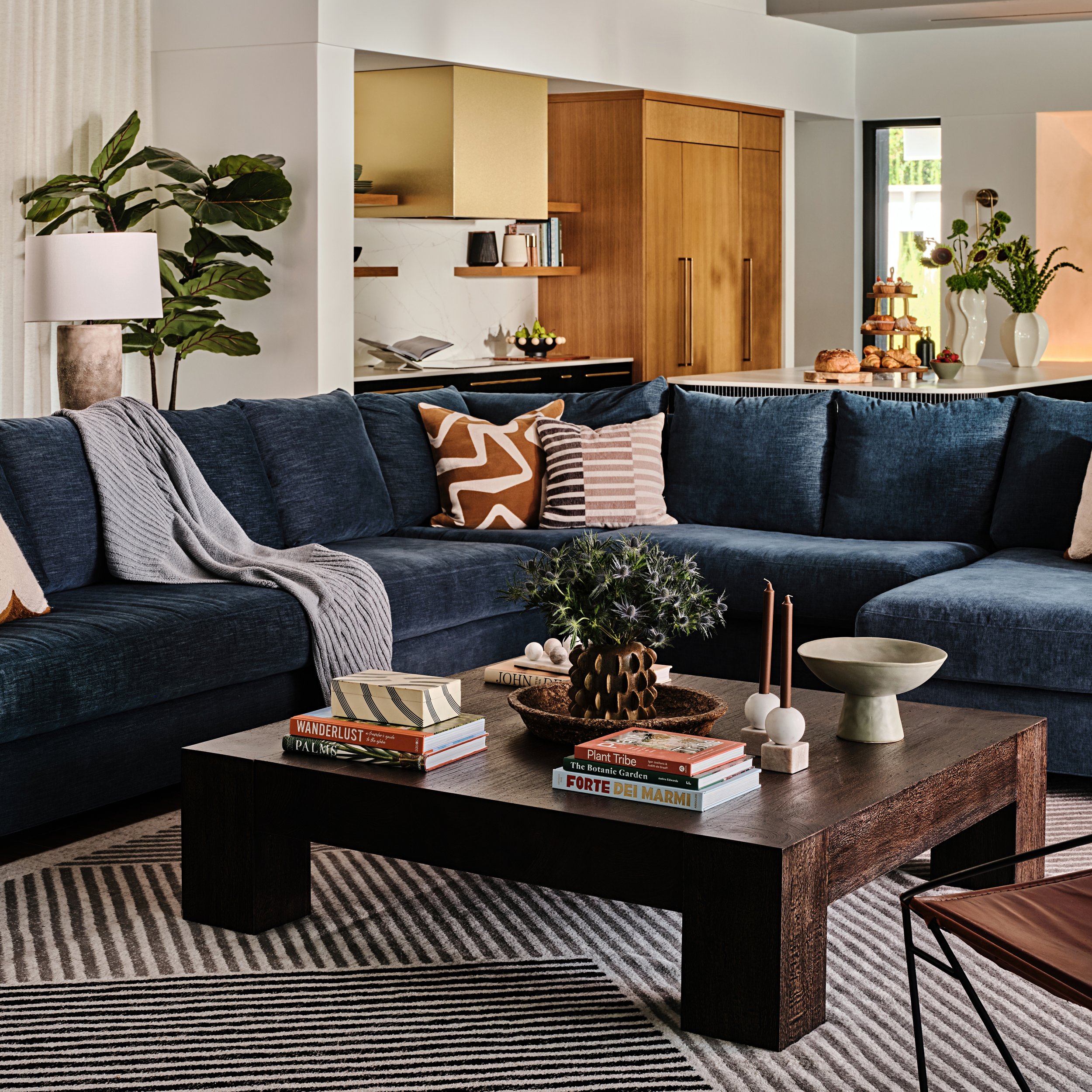 Navy blue sectional in a family room in Miami, Fl. Deep plush seating and dark wood coffee table. Interior design by Concept 2 Design. 
