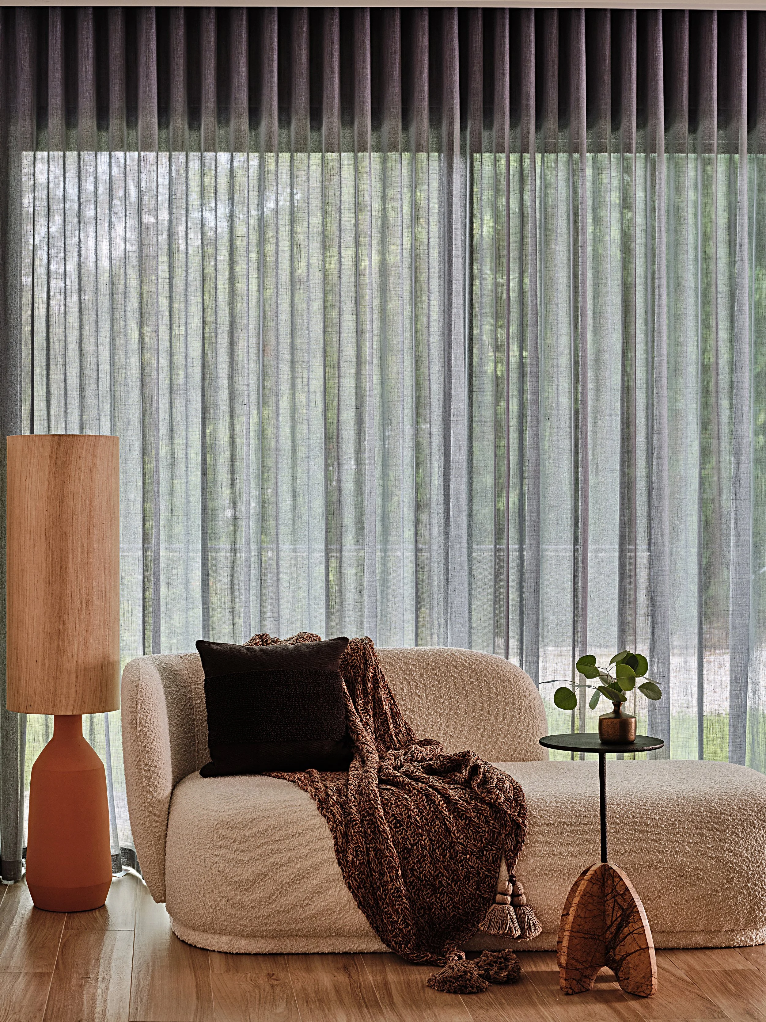 Moody interior design in a residential home in South Florida. Boucle chaise and terracotta floor lamp. Ripplefold drapery. Interior design by Concept 2 Design.