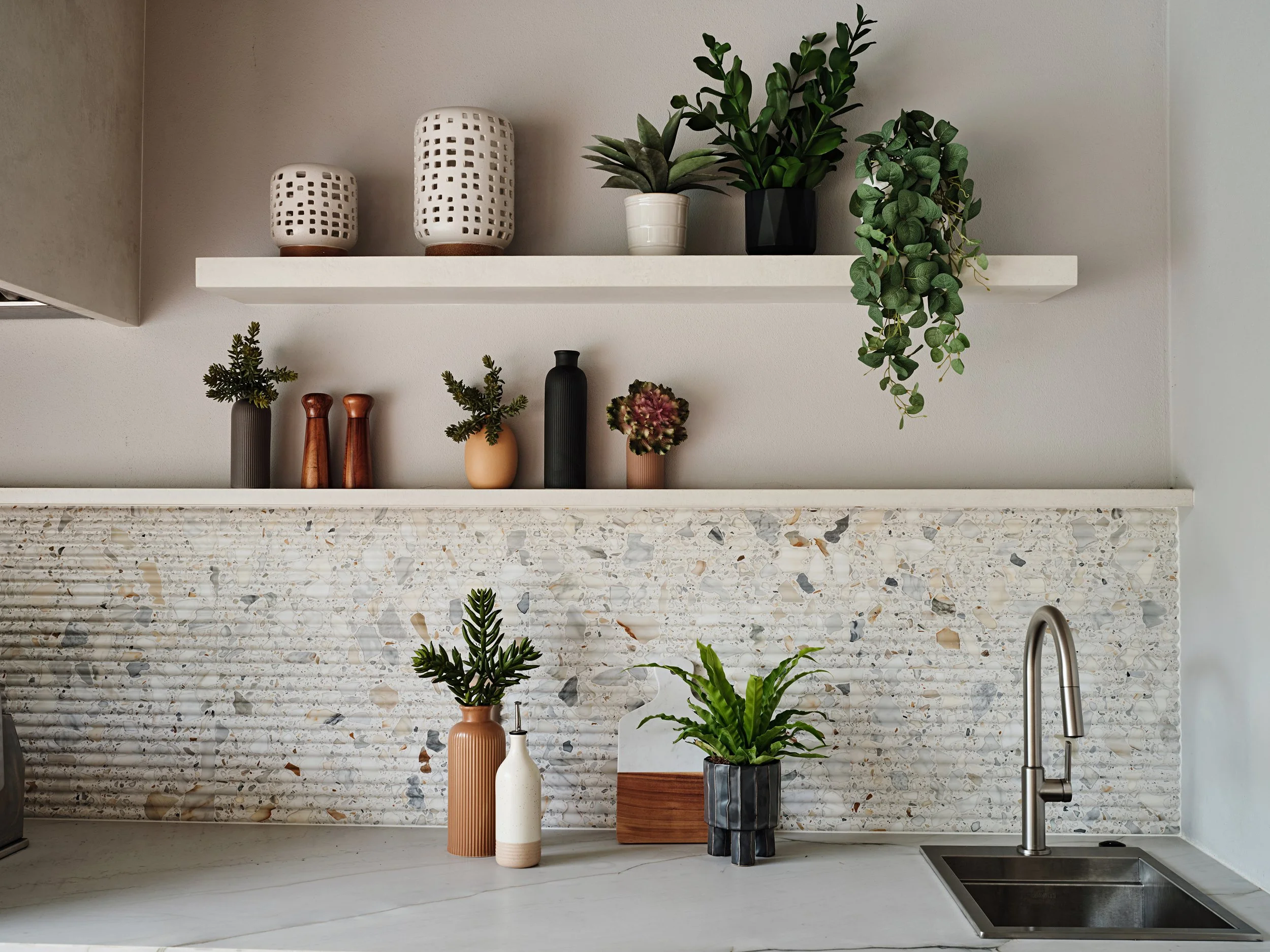 Outdoor kitchen open shelving with fluted terrazzo wall tile backsplash.