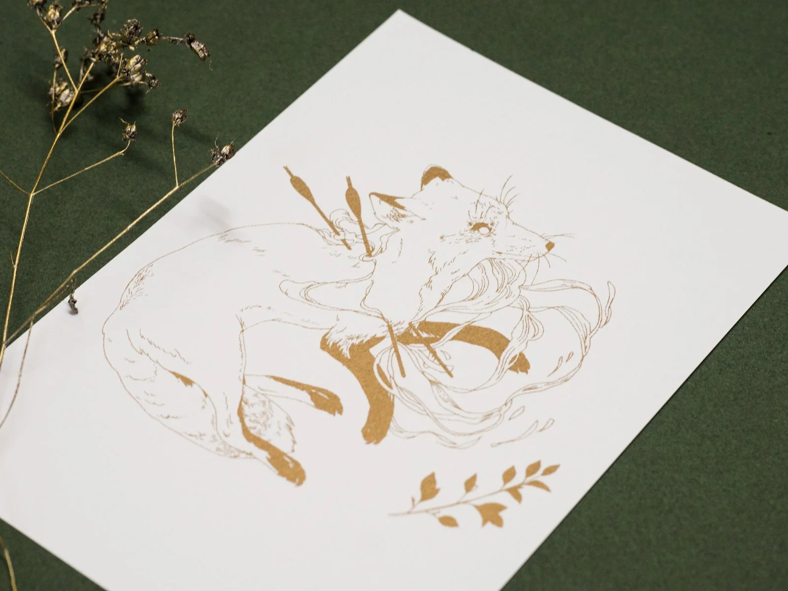Gold riso print of a wounded fox on white cardboard.
