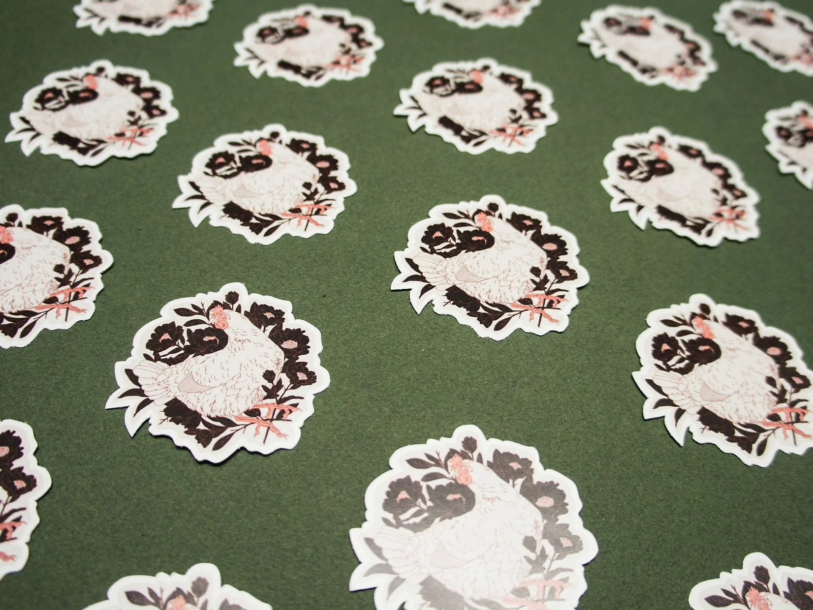 Freiformsticker eines Huhnes gebettet in dunklen Blumen.