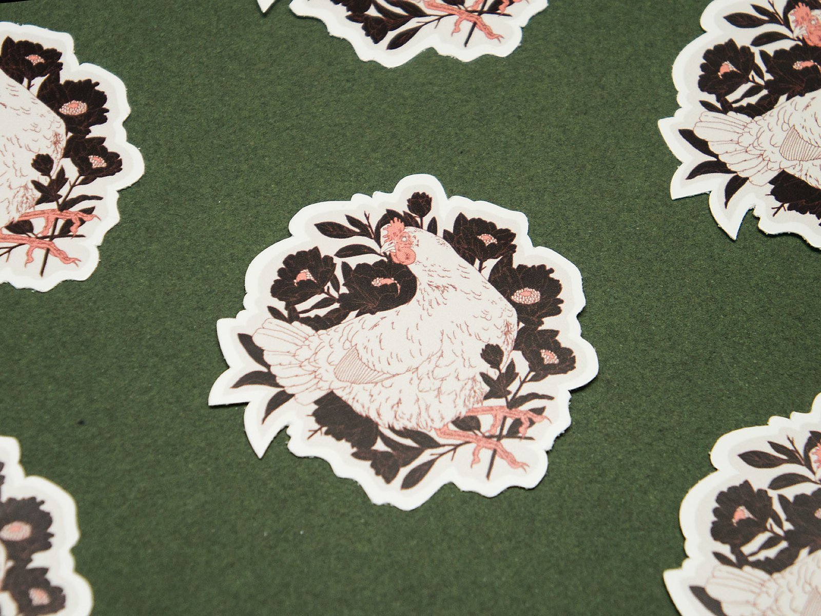 Freiformsticker eines Huhnes gebettet in dunklen Blumen.