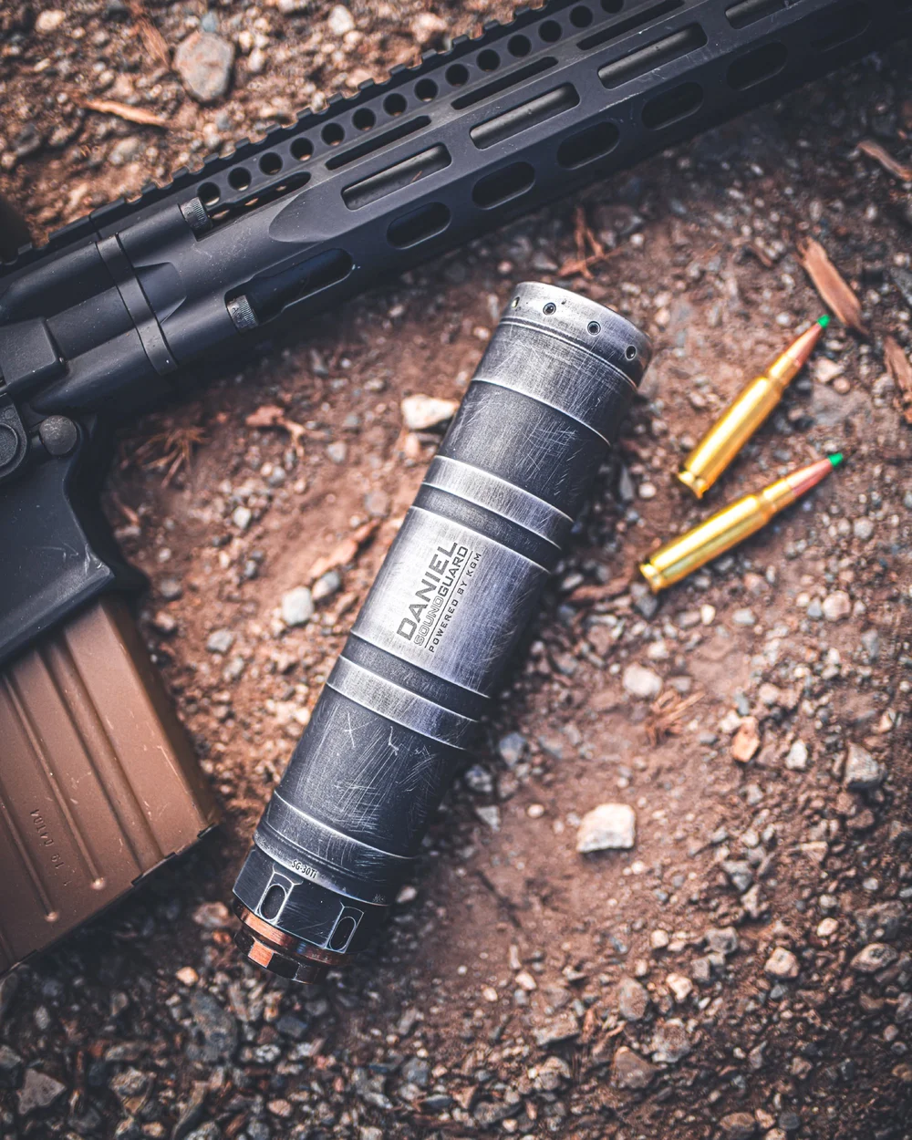 Suppressor and rifle cartridges on gravel