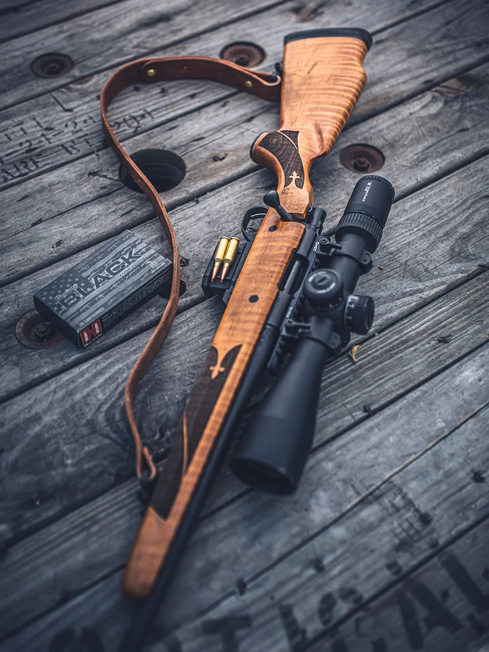 Lever-action rifle and scope on weathered wood