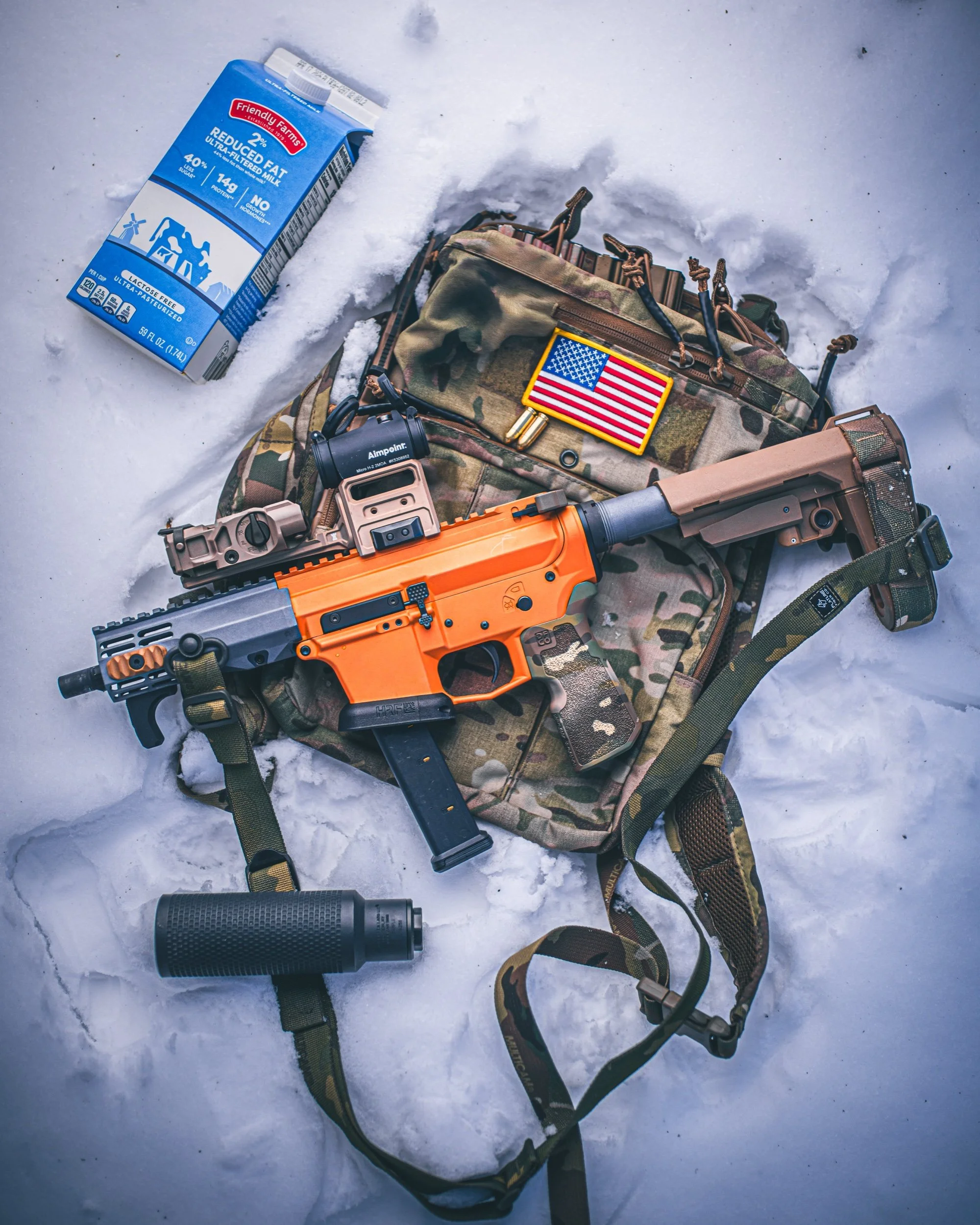 Firearm flat lay on snow with an American flag