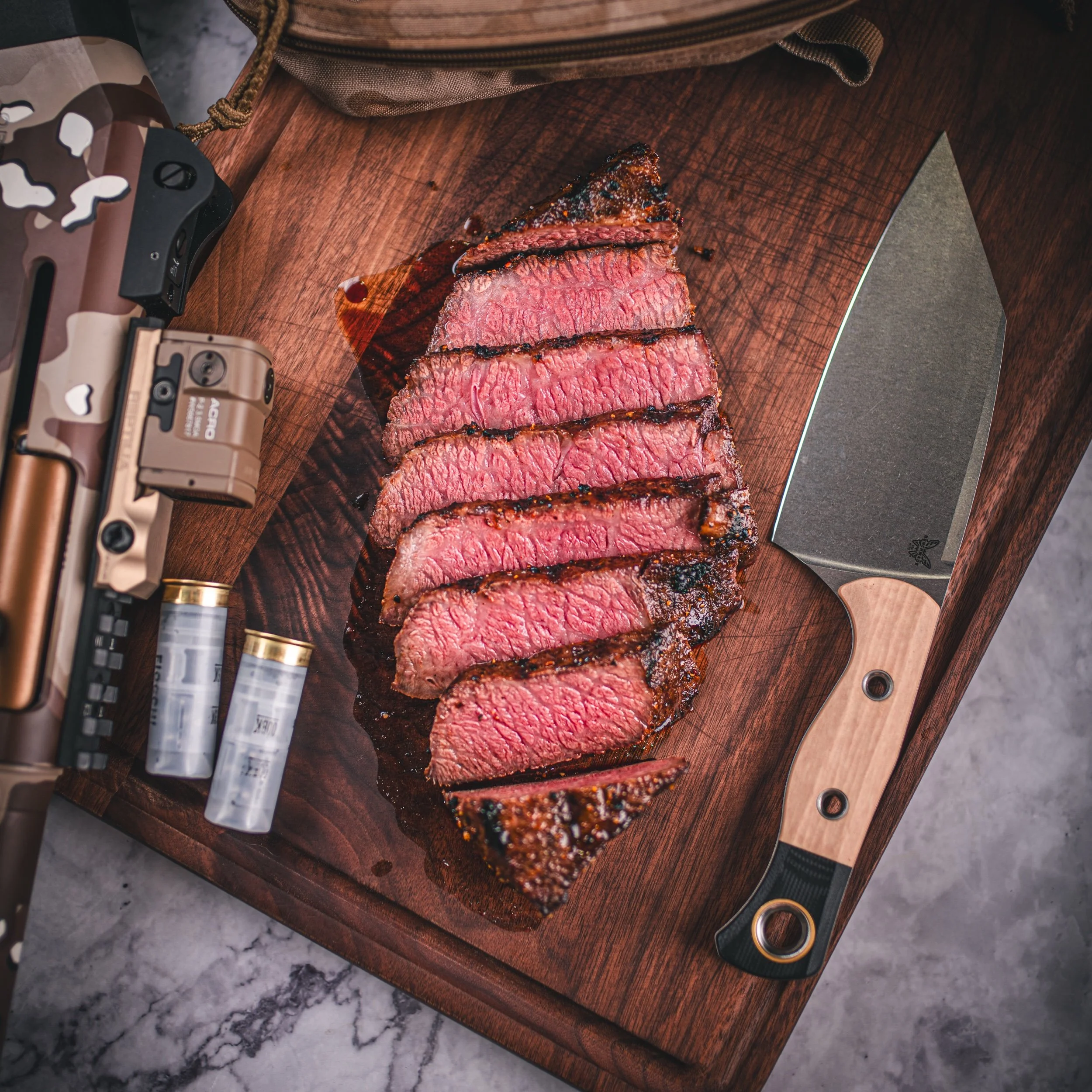 Steak plated beside a firearm on a cutting board