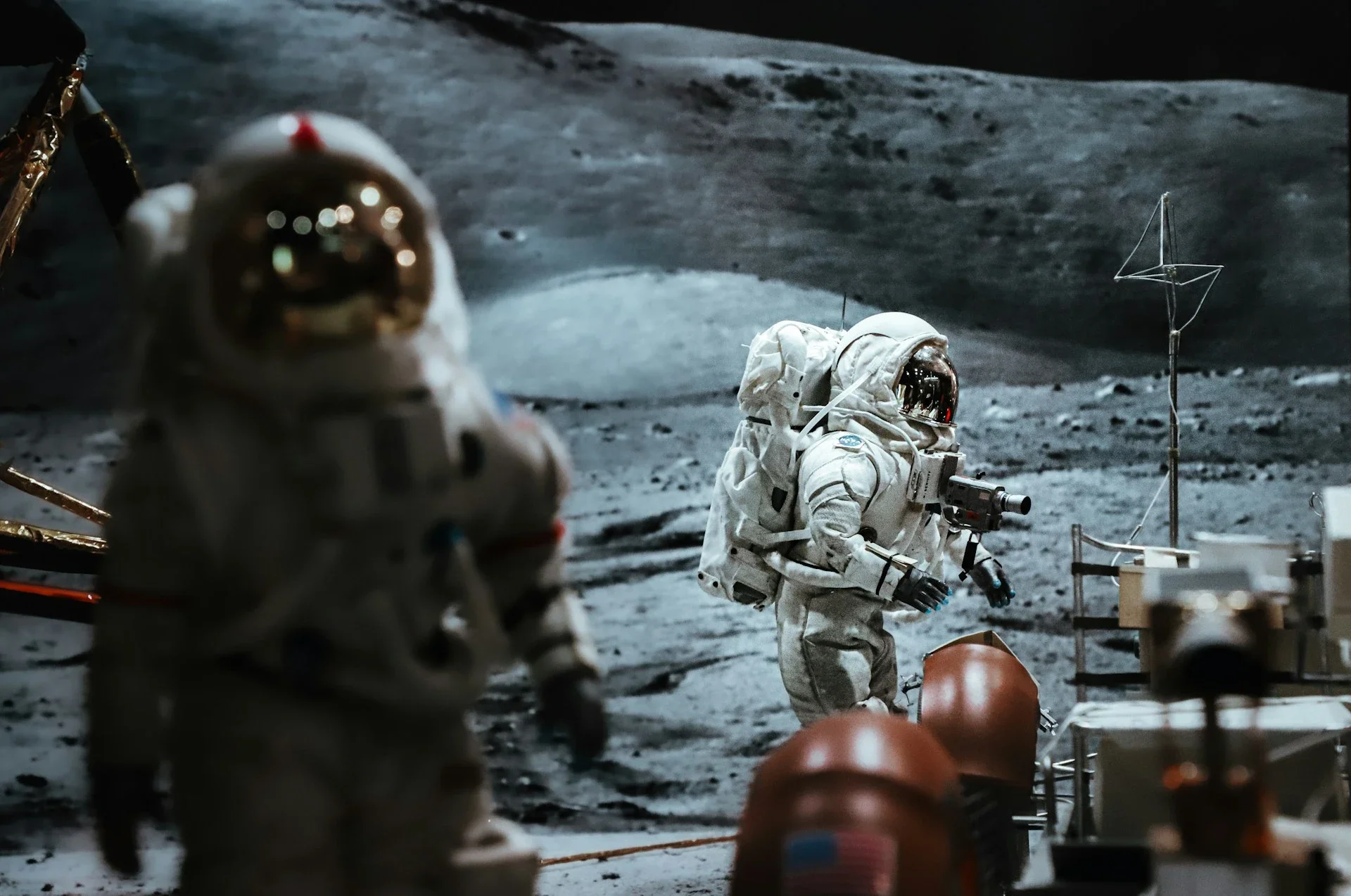 Astronauts conduct activities on the lunar surface, surrounded by equipment and a lunar rover.
