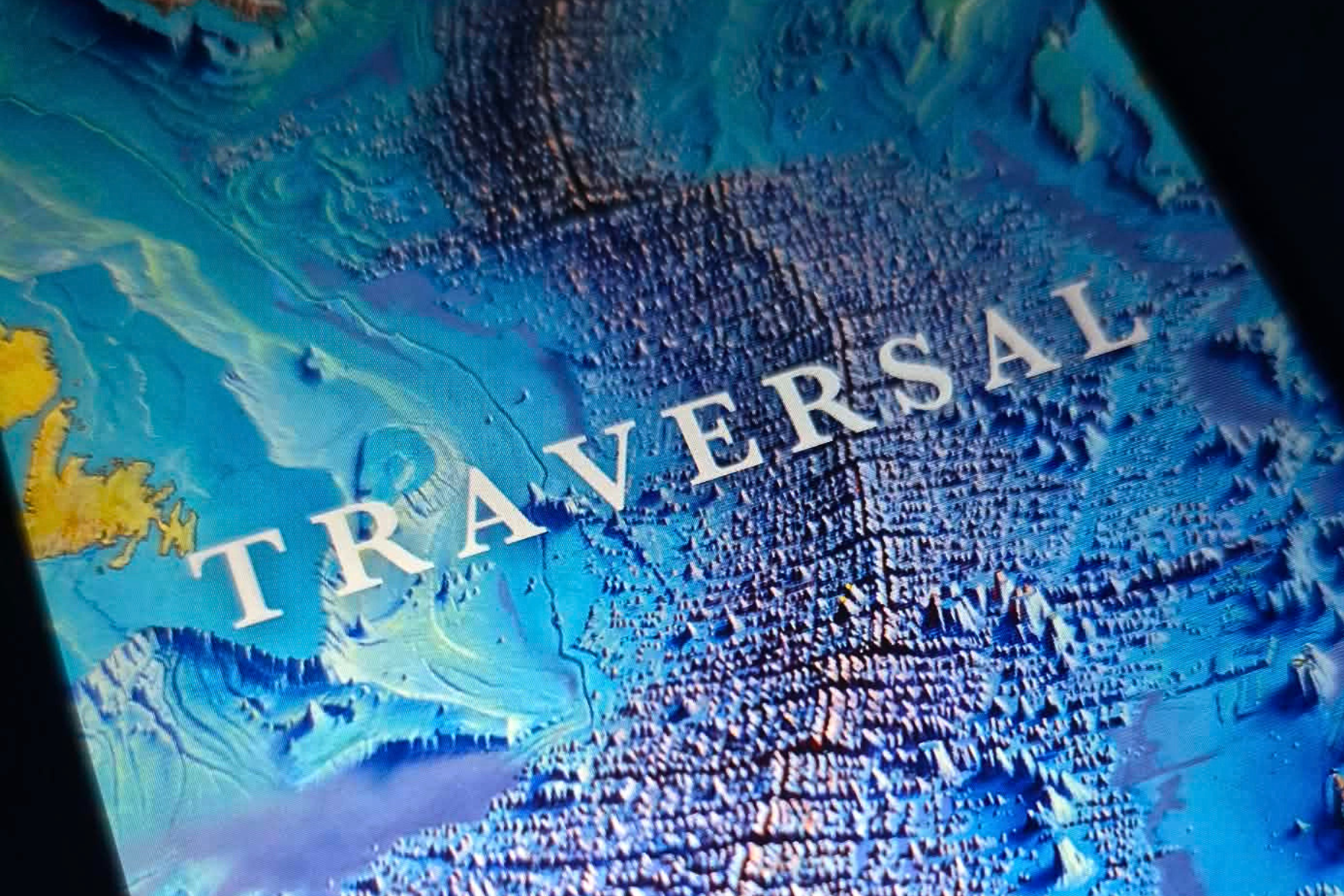 The book cover for Traversal by Maria Popova, featuring a textured, blue-toned topographical relief map of the ocean floor.