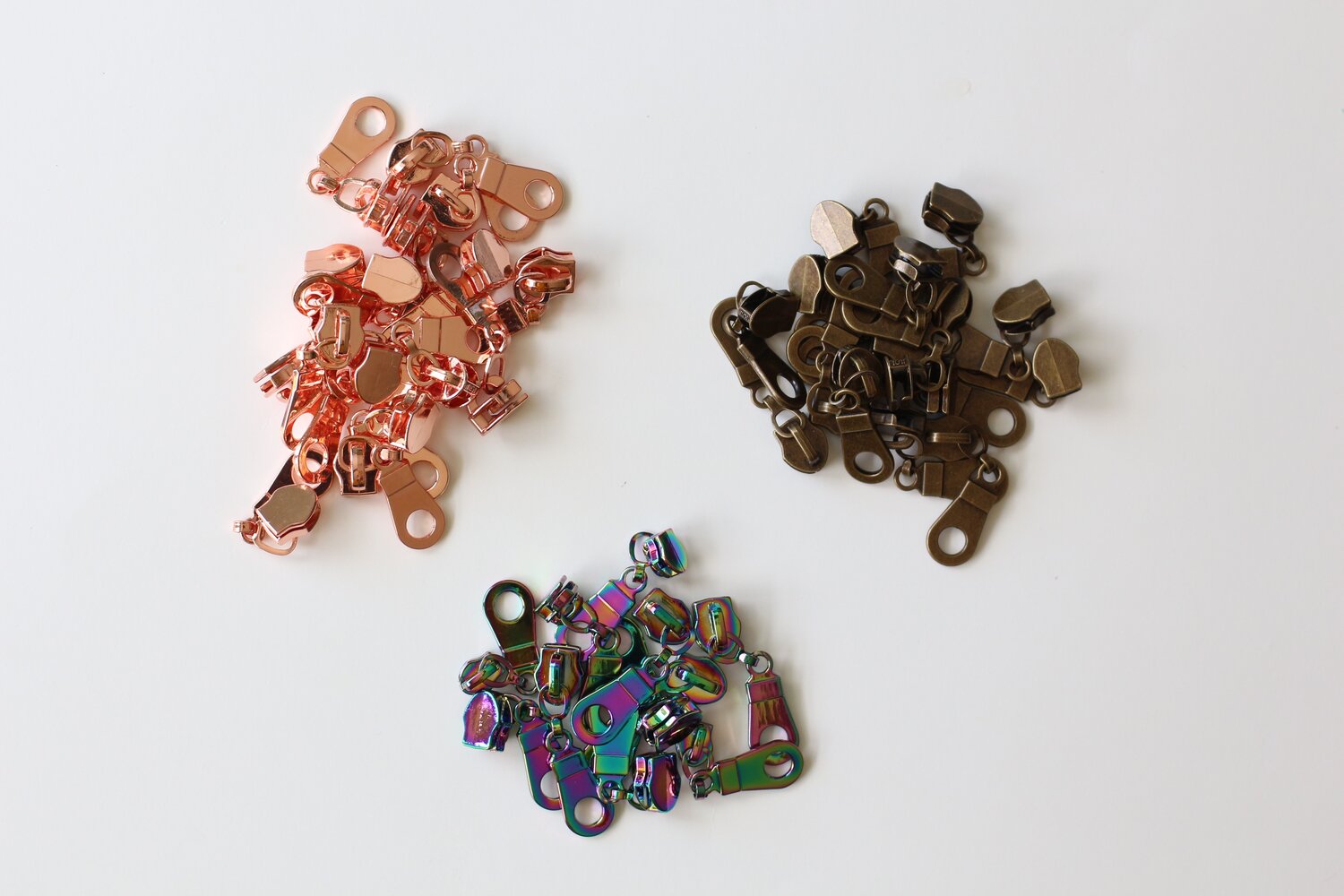 (Zipper pulls in a variety of finishes — rose gold, rainbow, antique bronze)