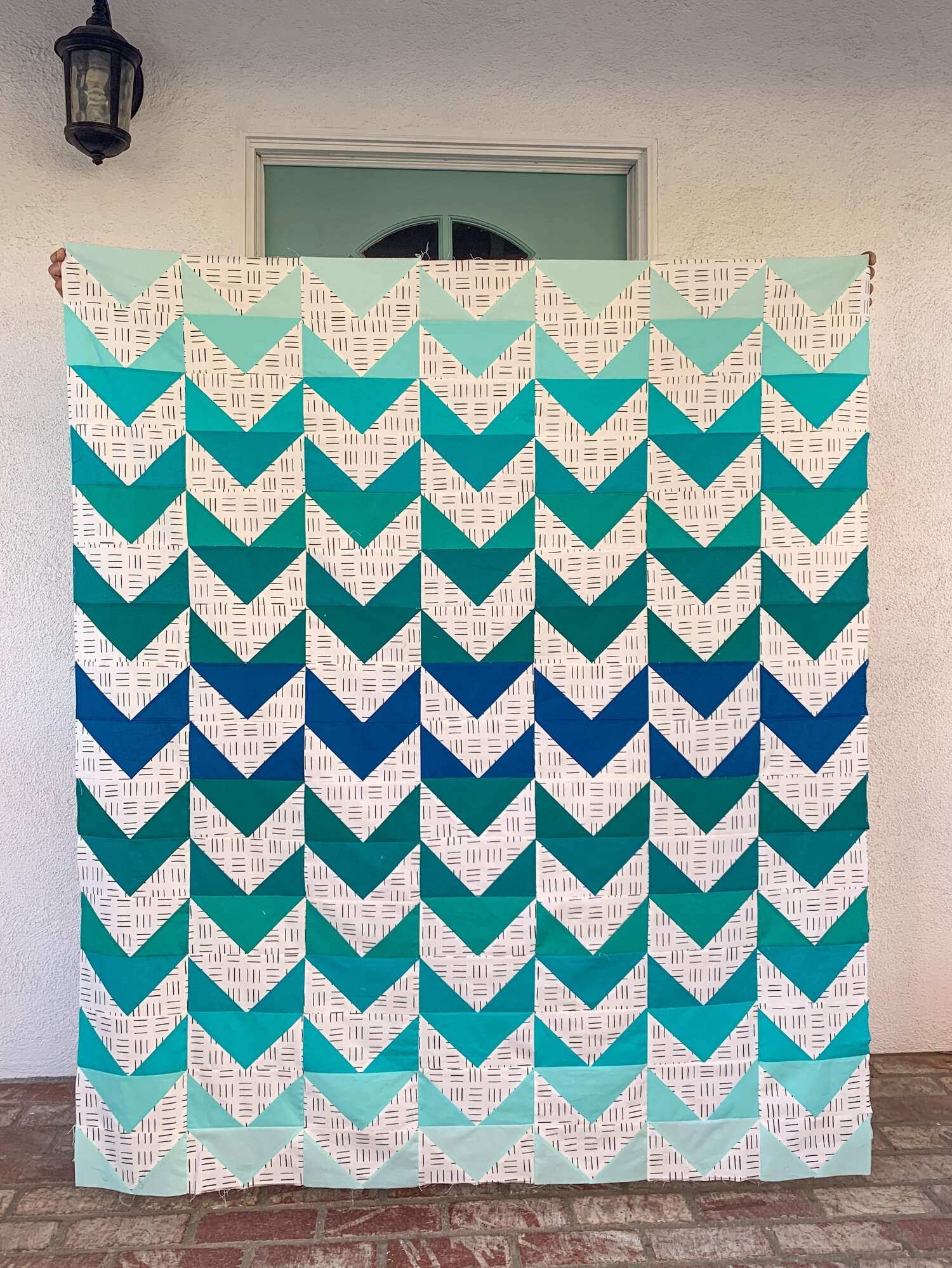 I absolutely adore Amy’s unique quilt! She used 1/2 the number of main fabrics and mirrored the colors in her quilt, pairing the gorgeous ombre solids with a simple, modern print for the background fabric. Amy has so many beautiful projects to browse through on her IG page @longlivehandmade.