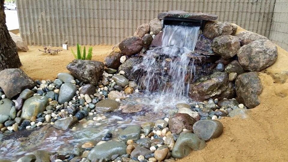 Landscaping Yuba City custom rock waterfall with decorative river rock and low-maintenance landscape design.