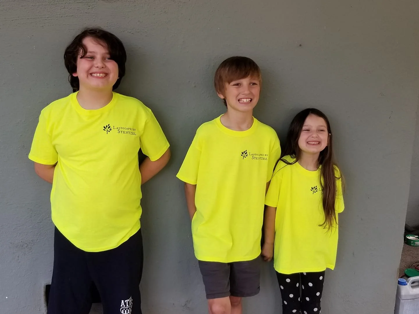 Next generation of the Landscapes by Stentzel family wearing company shirts and smiling together.