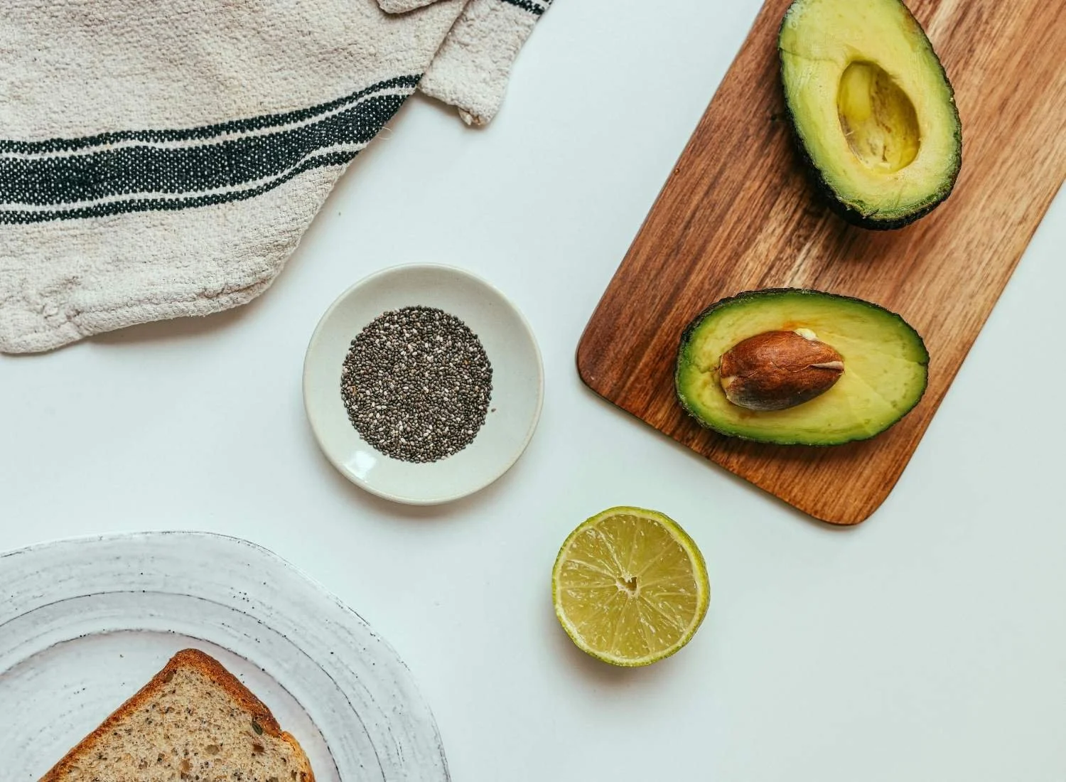Avocado, chia seeds and wholemeal toast on a white background.
