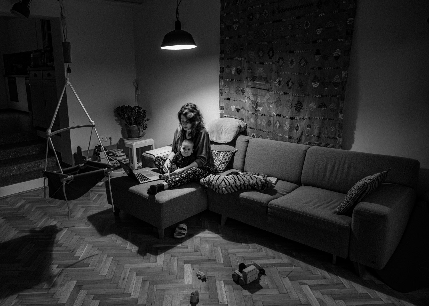   Helga  and her six months old baby  Zsiga  in their living room. Zsiga was born during the first lockdown in Hungary right after Helga and her sister started a new family business. Now, a few months later, she is back to work and managing the new b