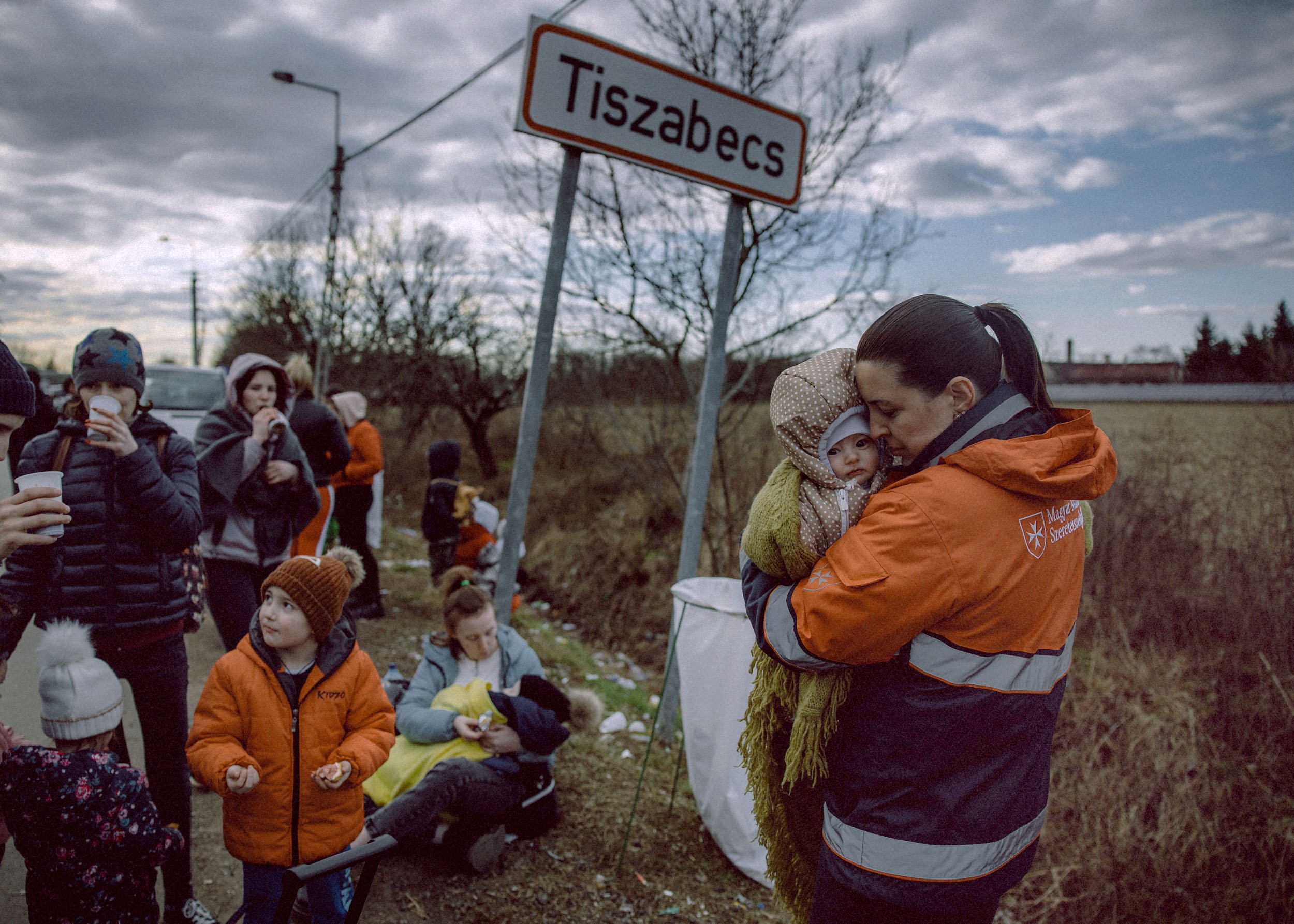  A volunteer holds a baby while people wait with their belongings at the Tiszabecs-Tiszaujlak border crossing as they flee Ukraine on February 27, 2022 in Tiszabecs, Hungary. More than 2 million refugees have fled Ukraine since the start of Russia's 