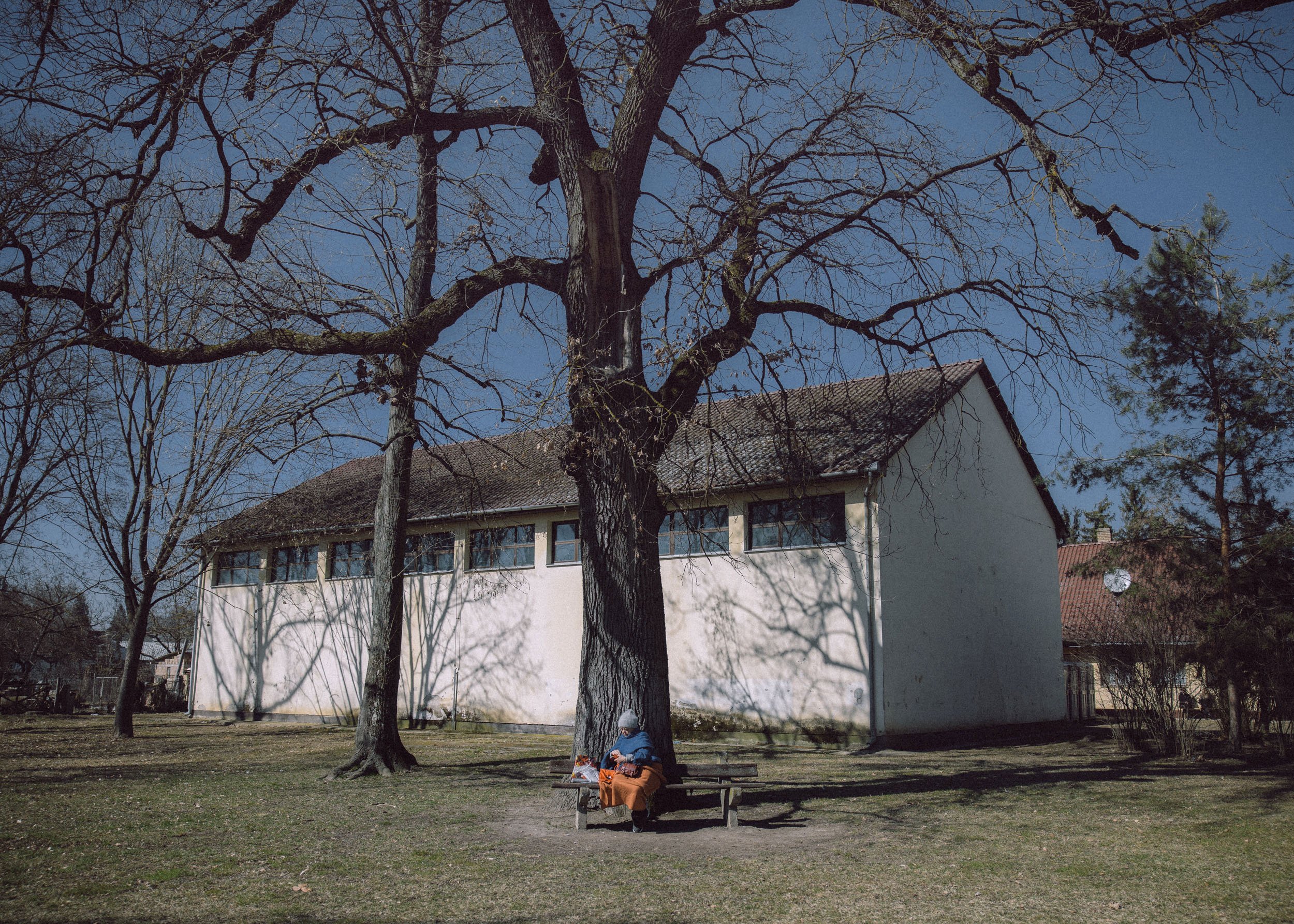  A woman has lunch behind the building of the temporary shelter developed from a sport hall on March 19, 2022 in Beregsurany, Hungary 