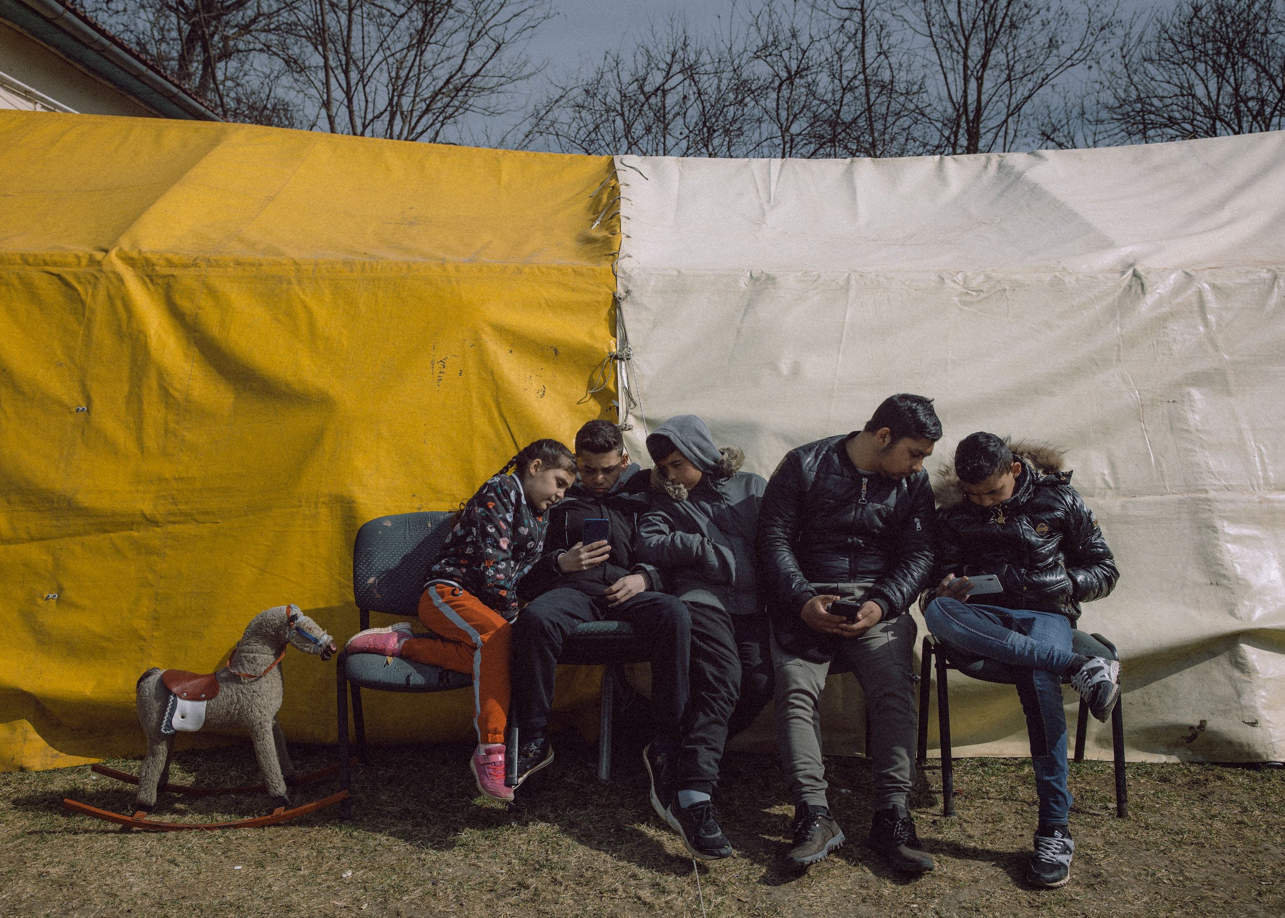  A refugee family sit in front of a tent at a temporary shelter offered by the "Free Christian Church" on March 20, 2022 in Uszka, Hungary 