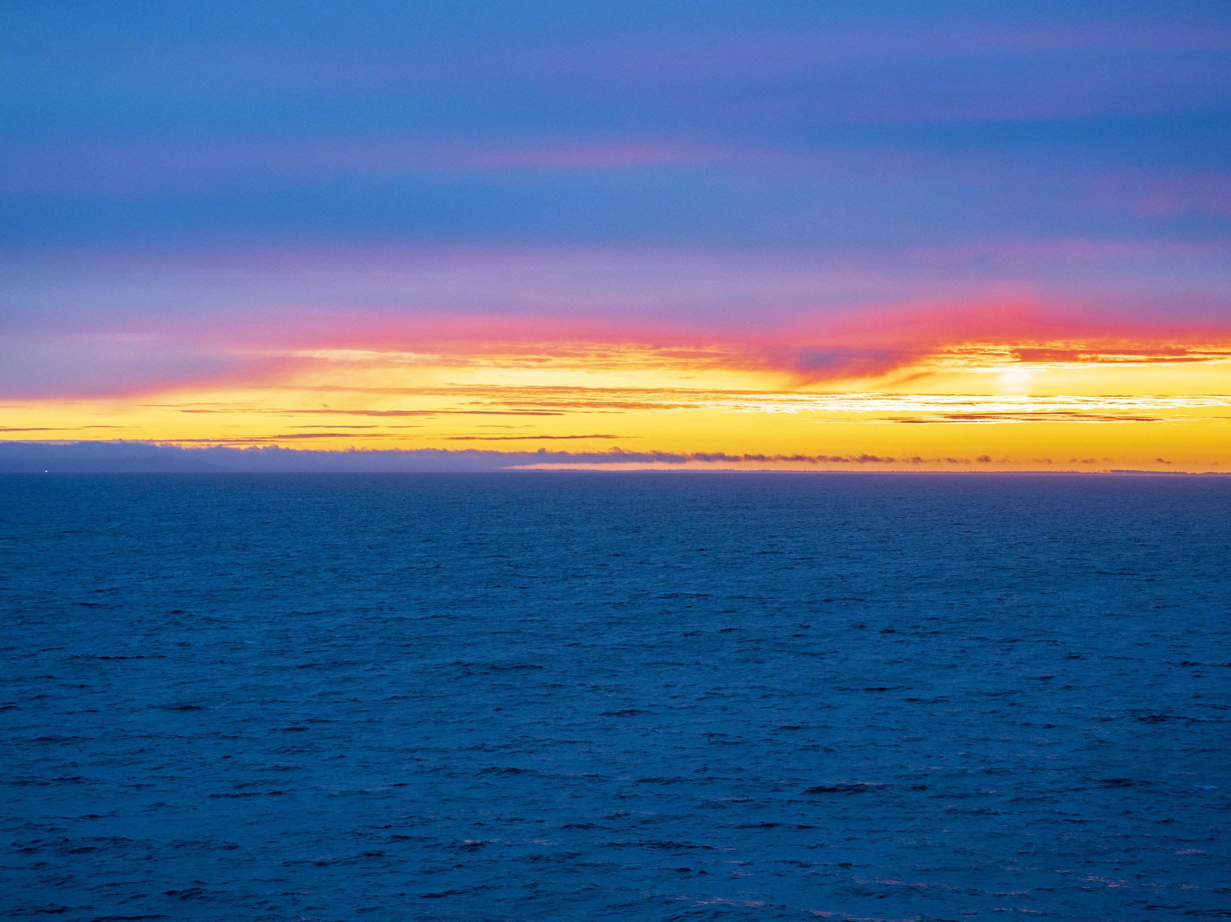 A yellow and pink sunset drifting toward blue hour.