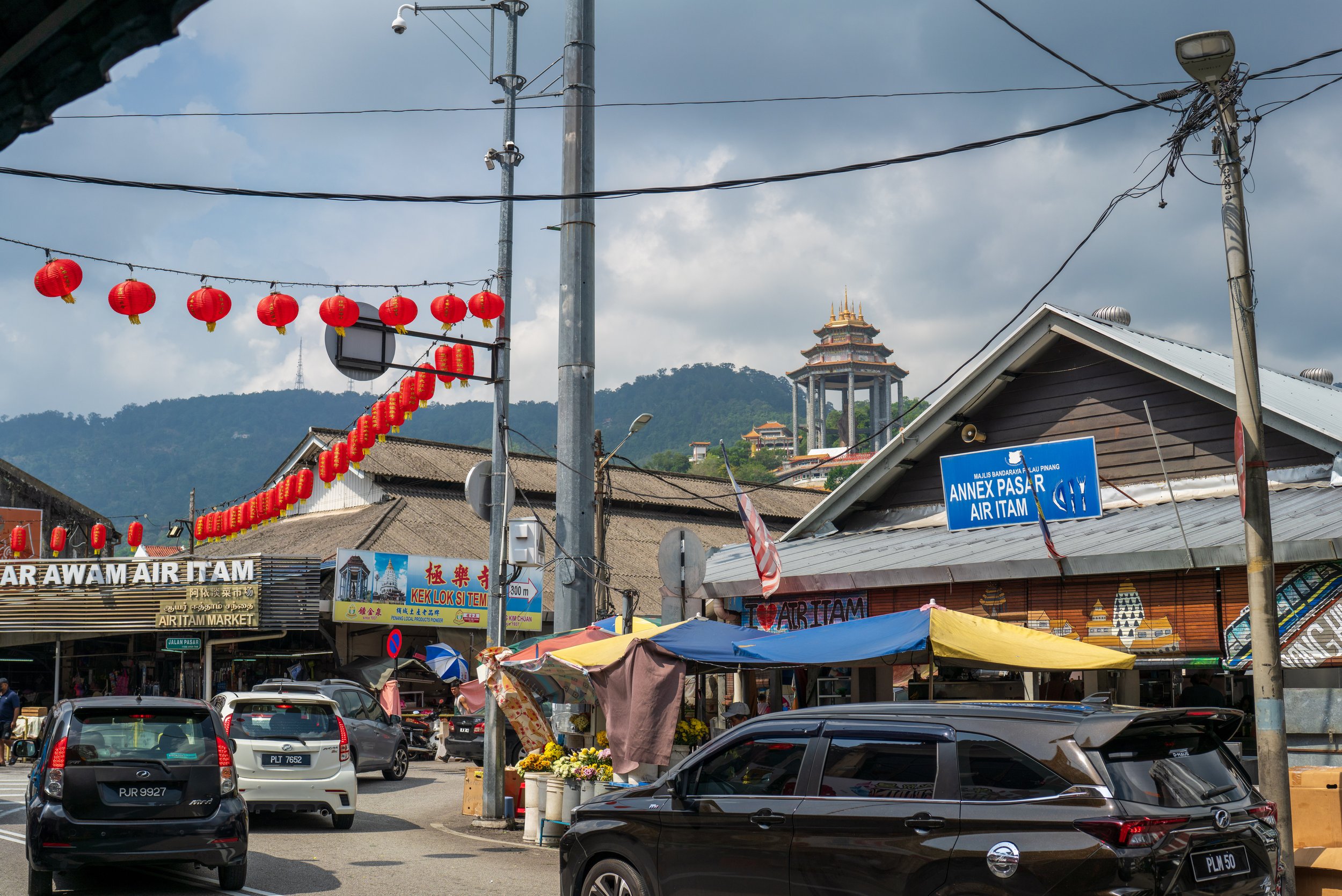 Looking up from a busy street at the large statue tower.