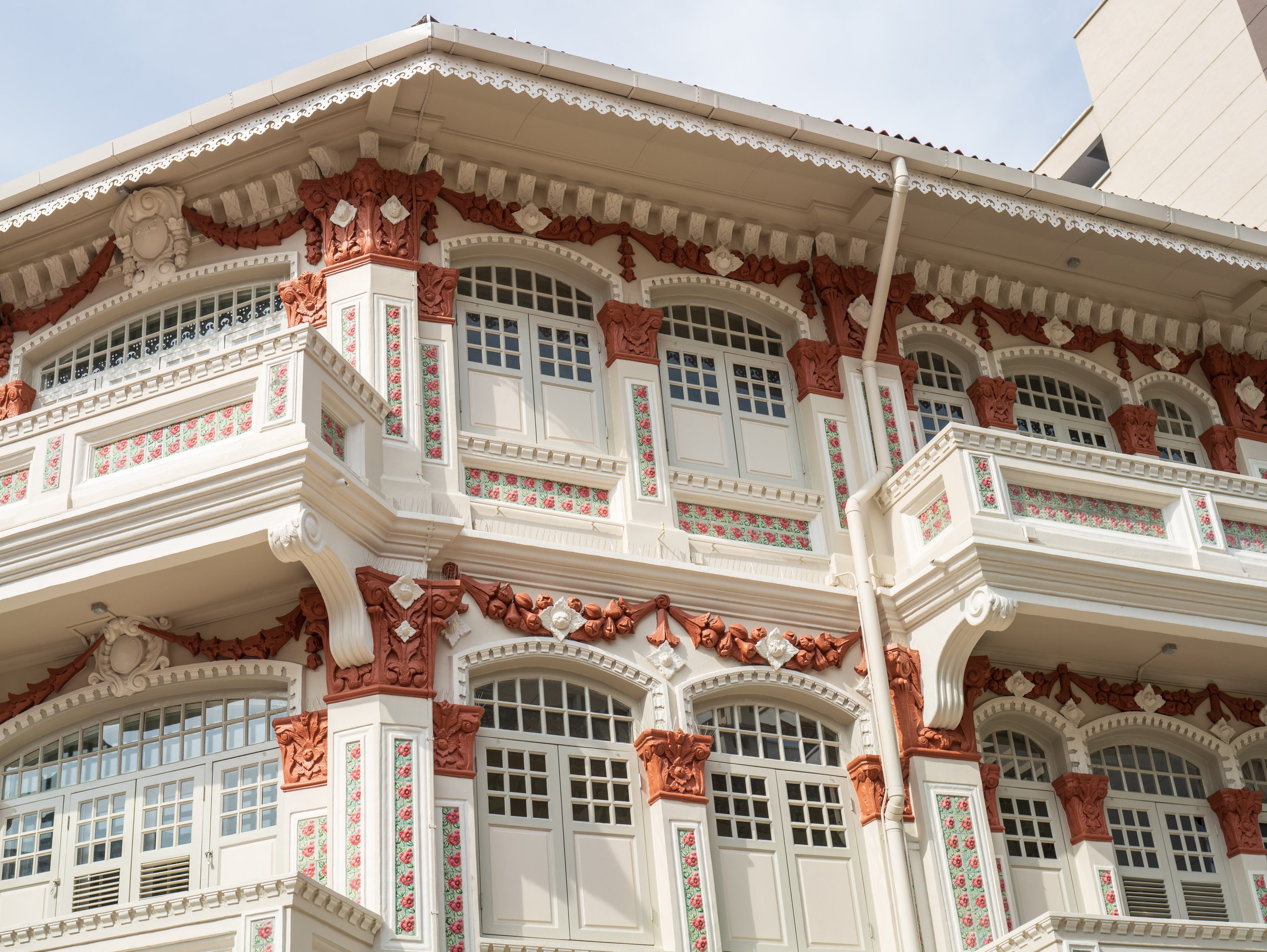 A colonial-style building with red and beige ornate siding.