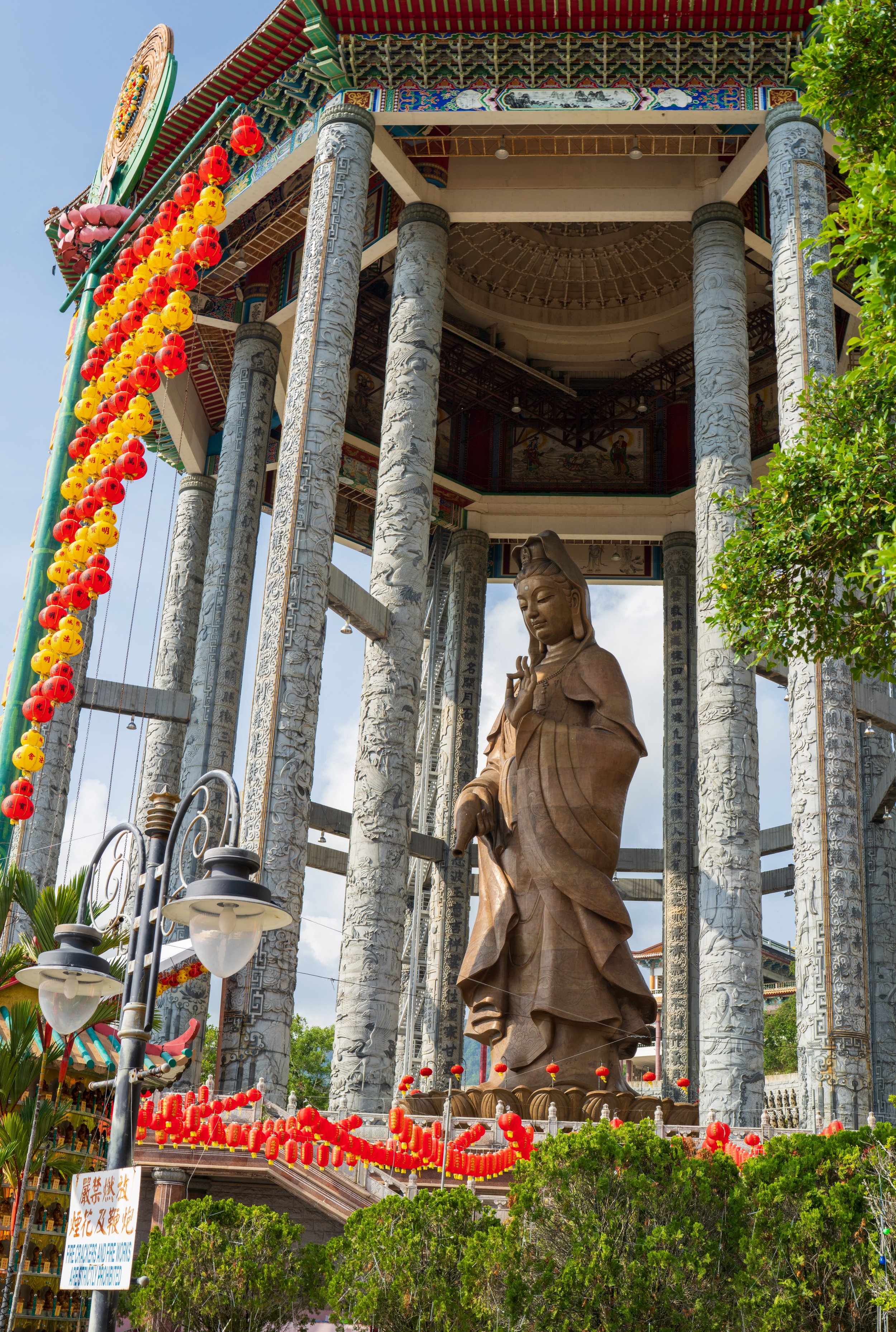 A huge statue under an ornate roof.