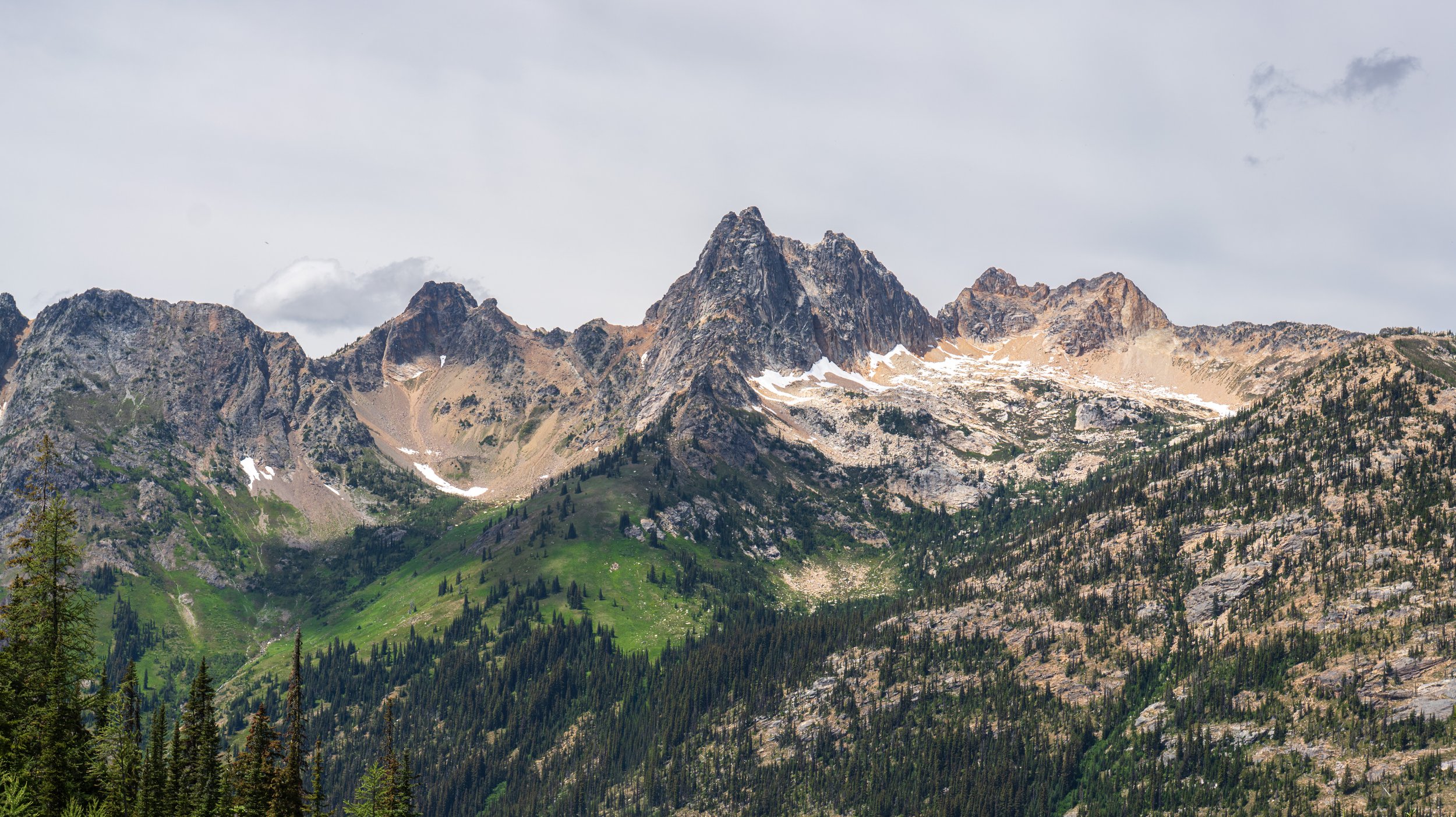 Looking out over a mountainous forest at a mountain peak.