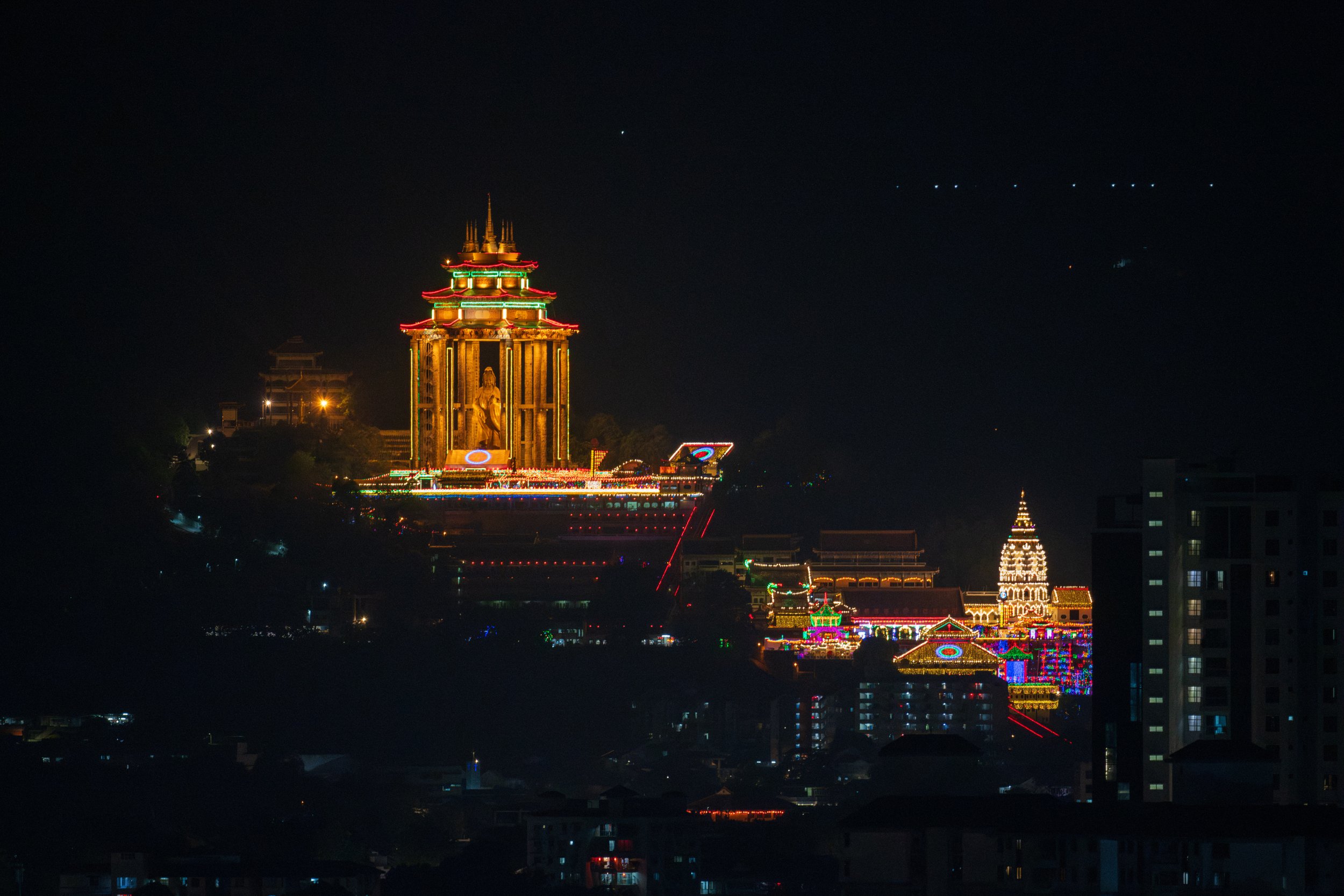 View of the temple lit up at night from afar.