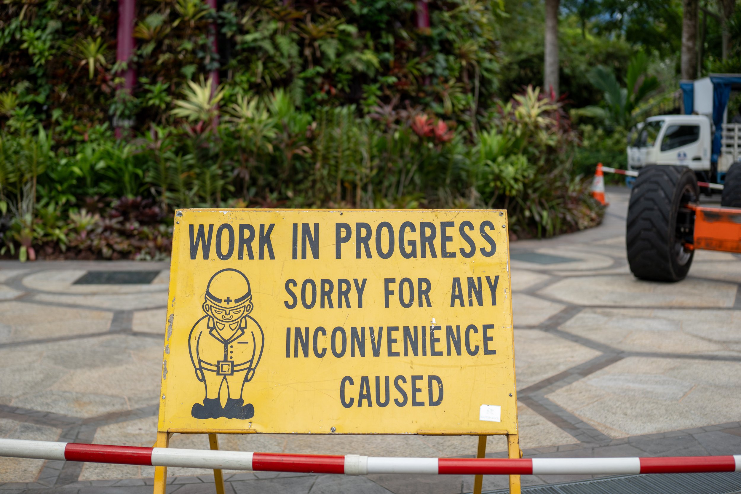 A sign with a person bowing that says "work in progress, sorry for an inconvenience caused."