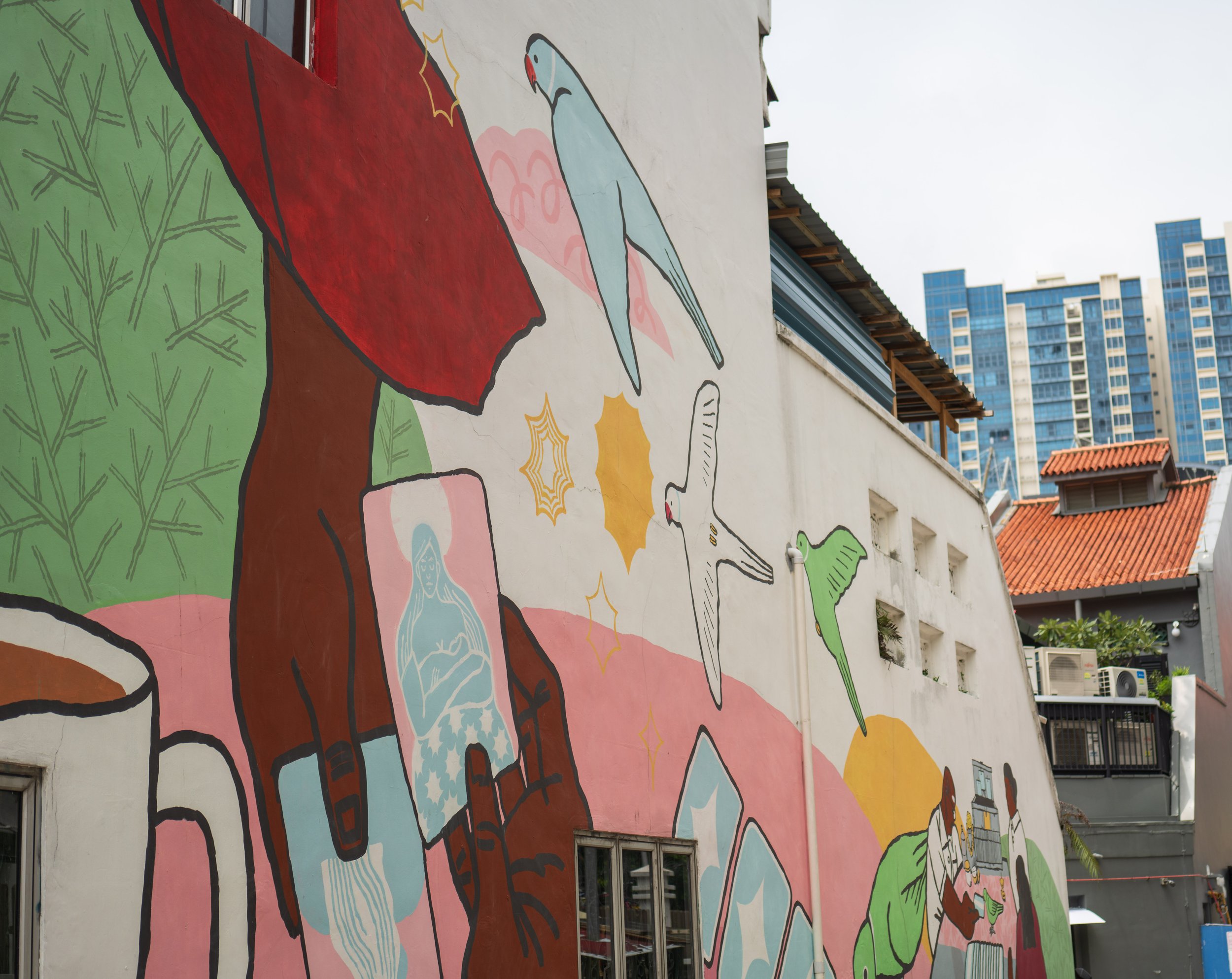 A mural of birds and hands holding playing cards.