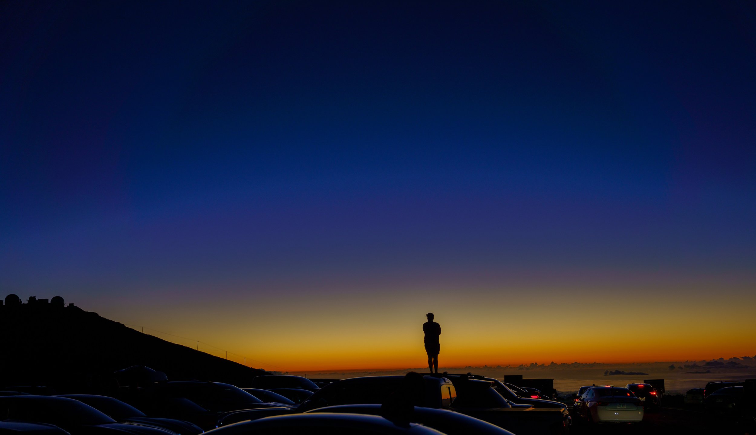  A man watches the sunset fade from the roof of his car (photo/Jason Rafal) 