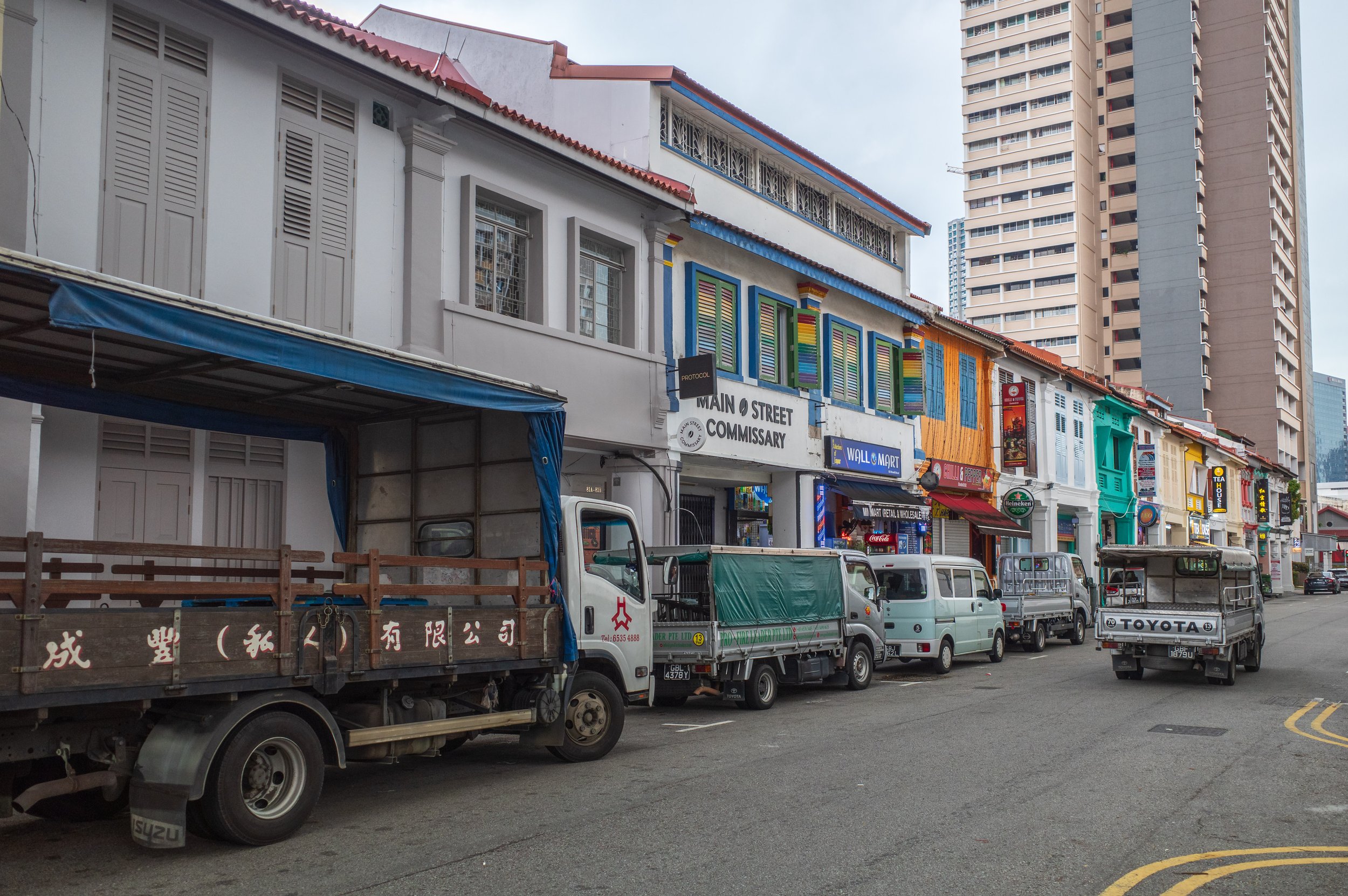 Small trucks and vans on a street in front of a store called Wall Mart.